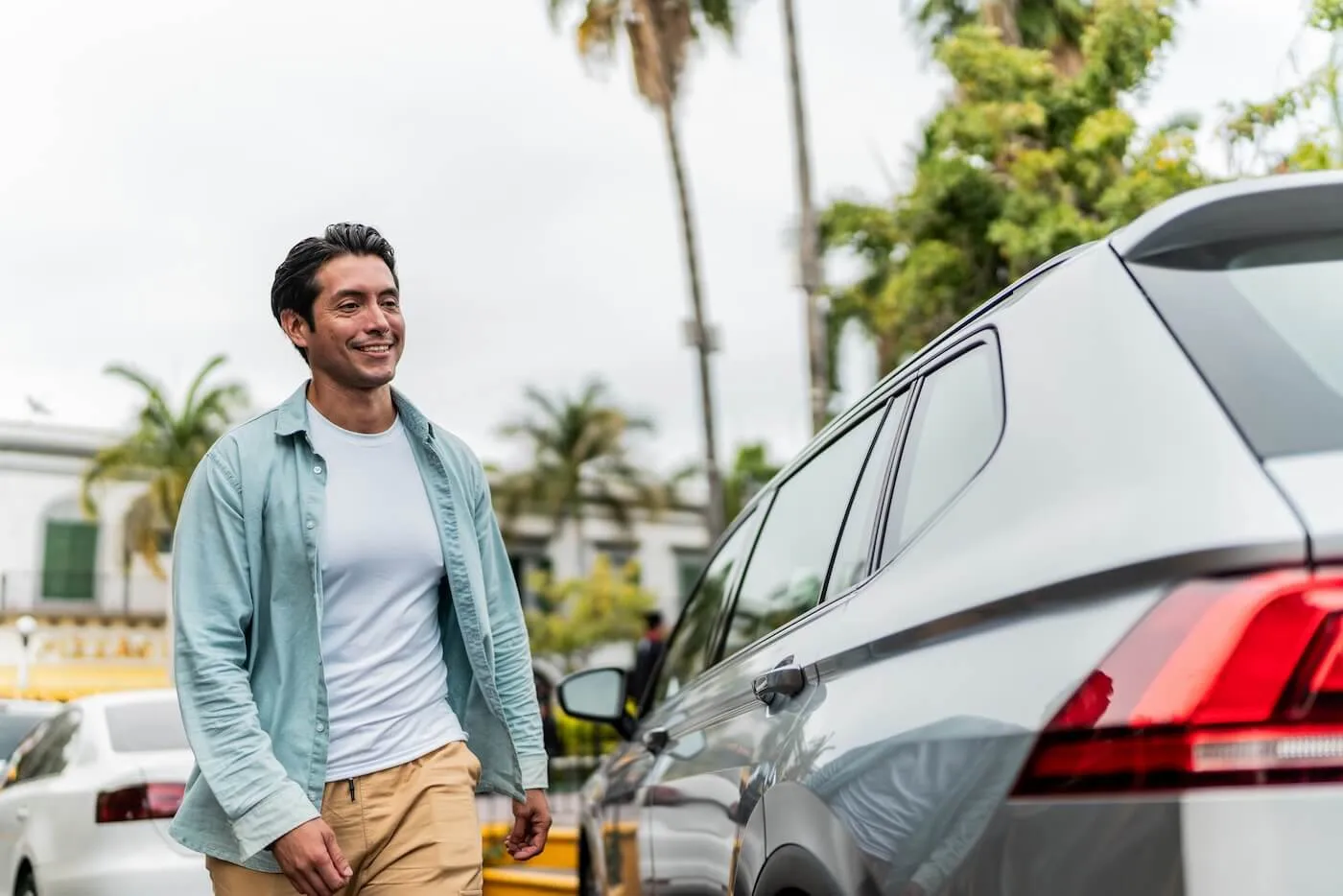 Happy man walking toward his new car