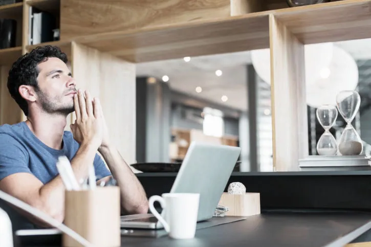 Pensive man at laptop in home office