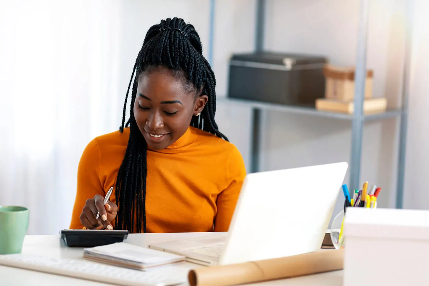 Close up of a woman using calculator, calculating finance at home.