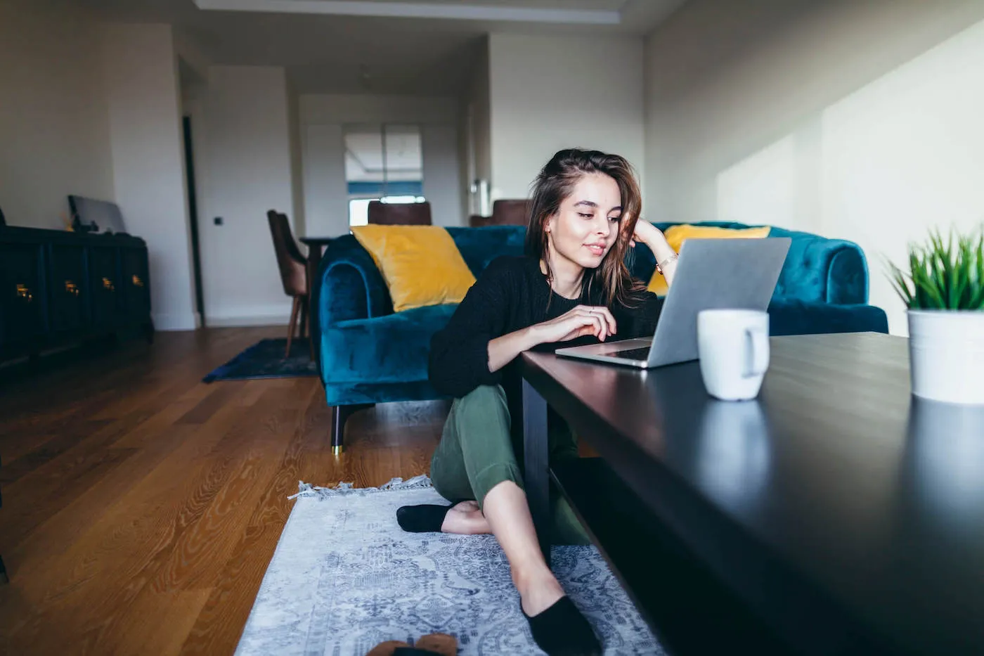 A young woman is using a laptop at home.