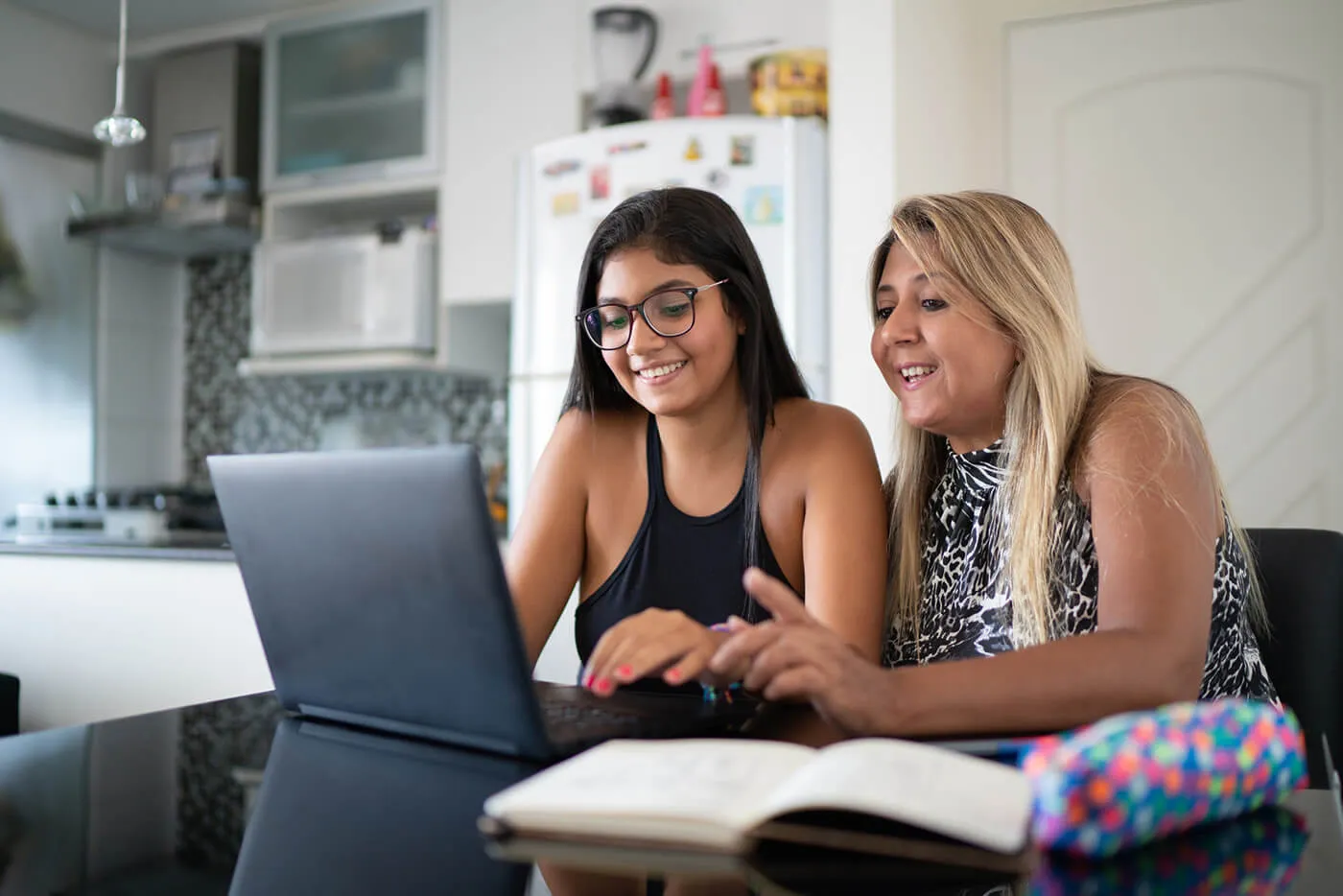 Mother and daughter using laptop at home