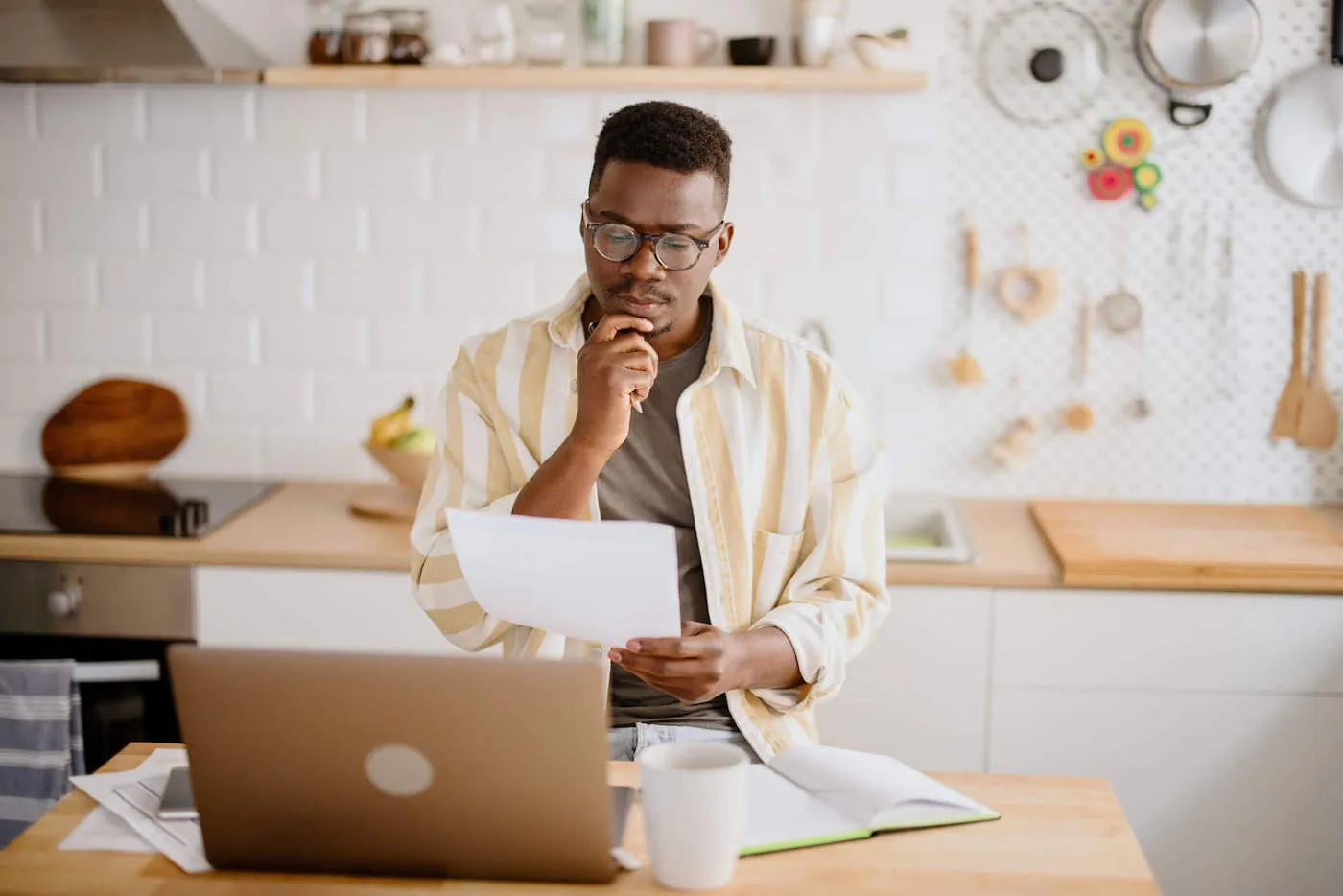 seated man in a thinking pose while looking at paper