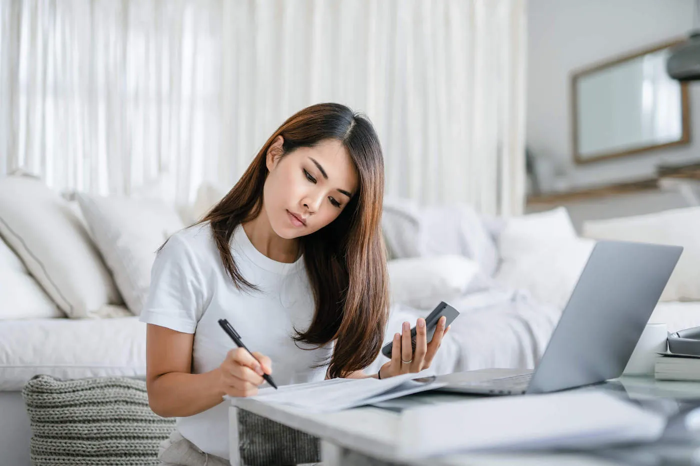 young woman holding phone while making student loan payment