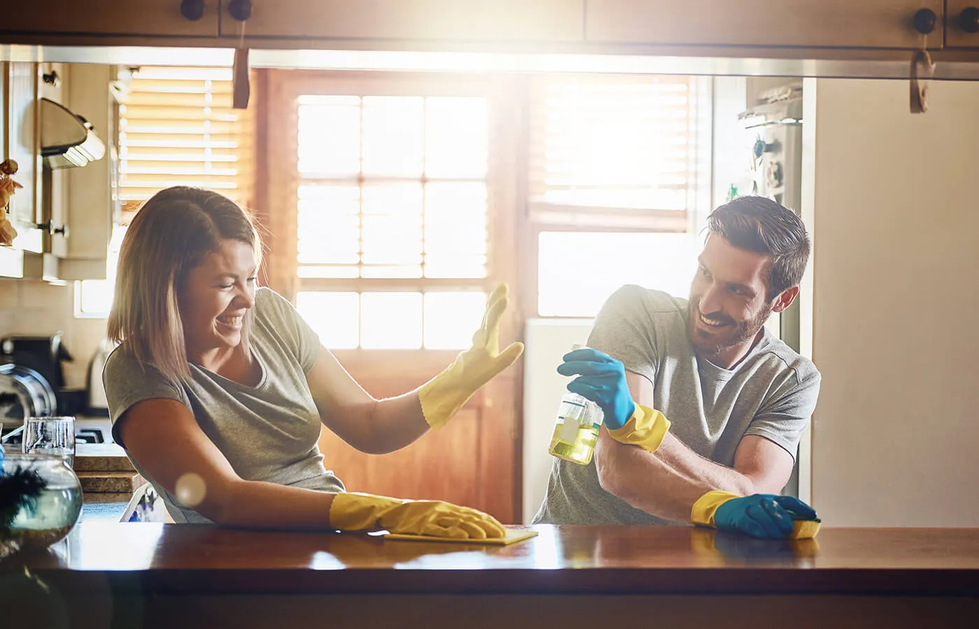 A young couple having fun while doing home chores together.