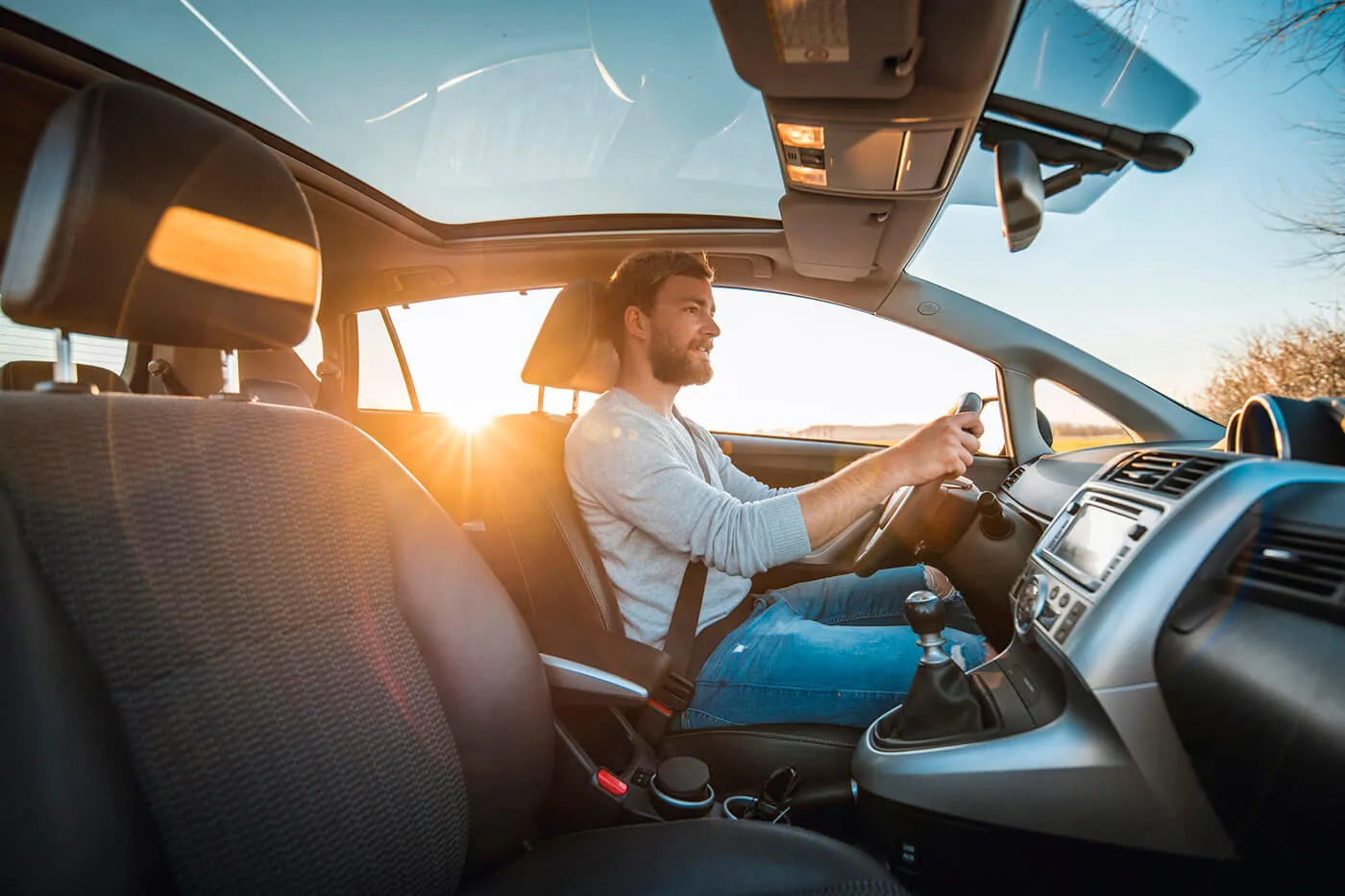 Young man driving car on a sunny day