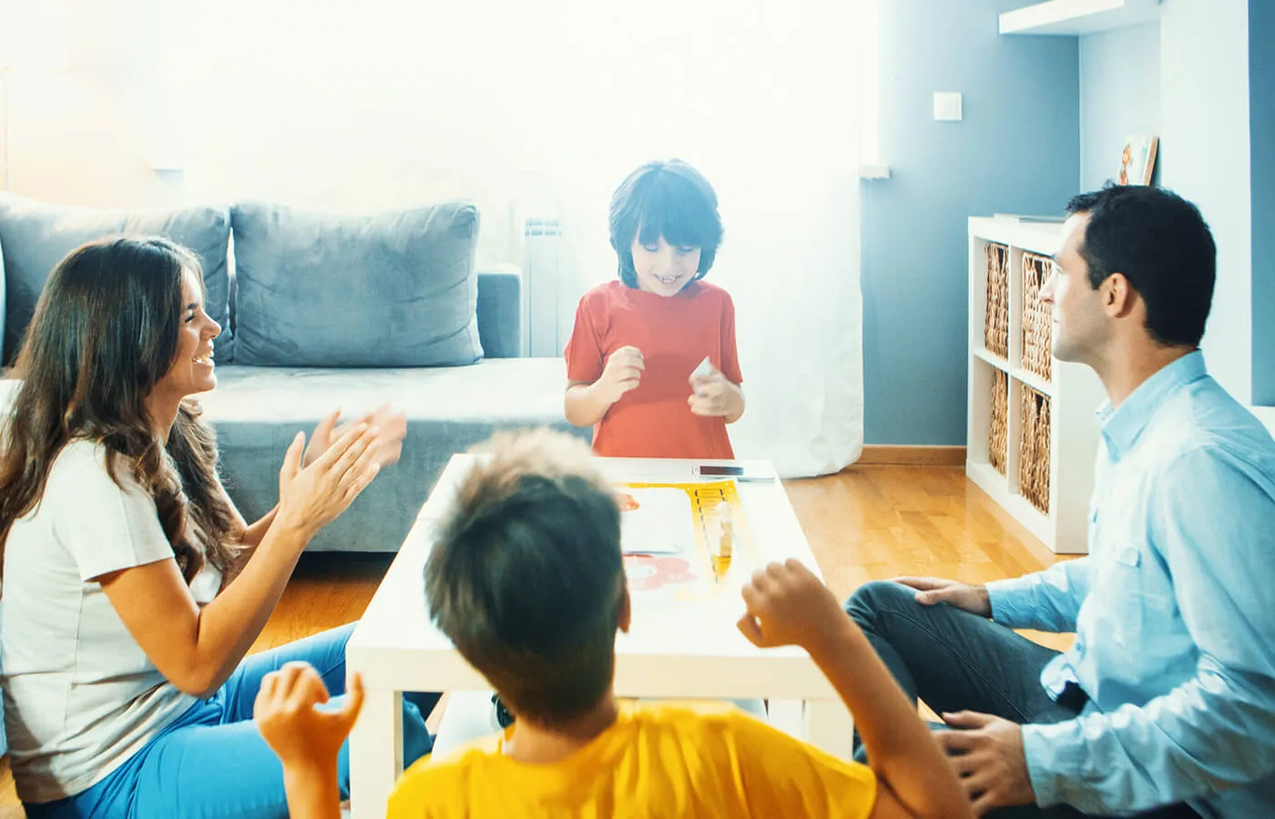 A family of four playing board games in their living room.