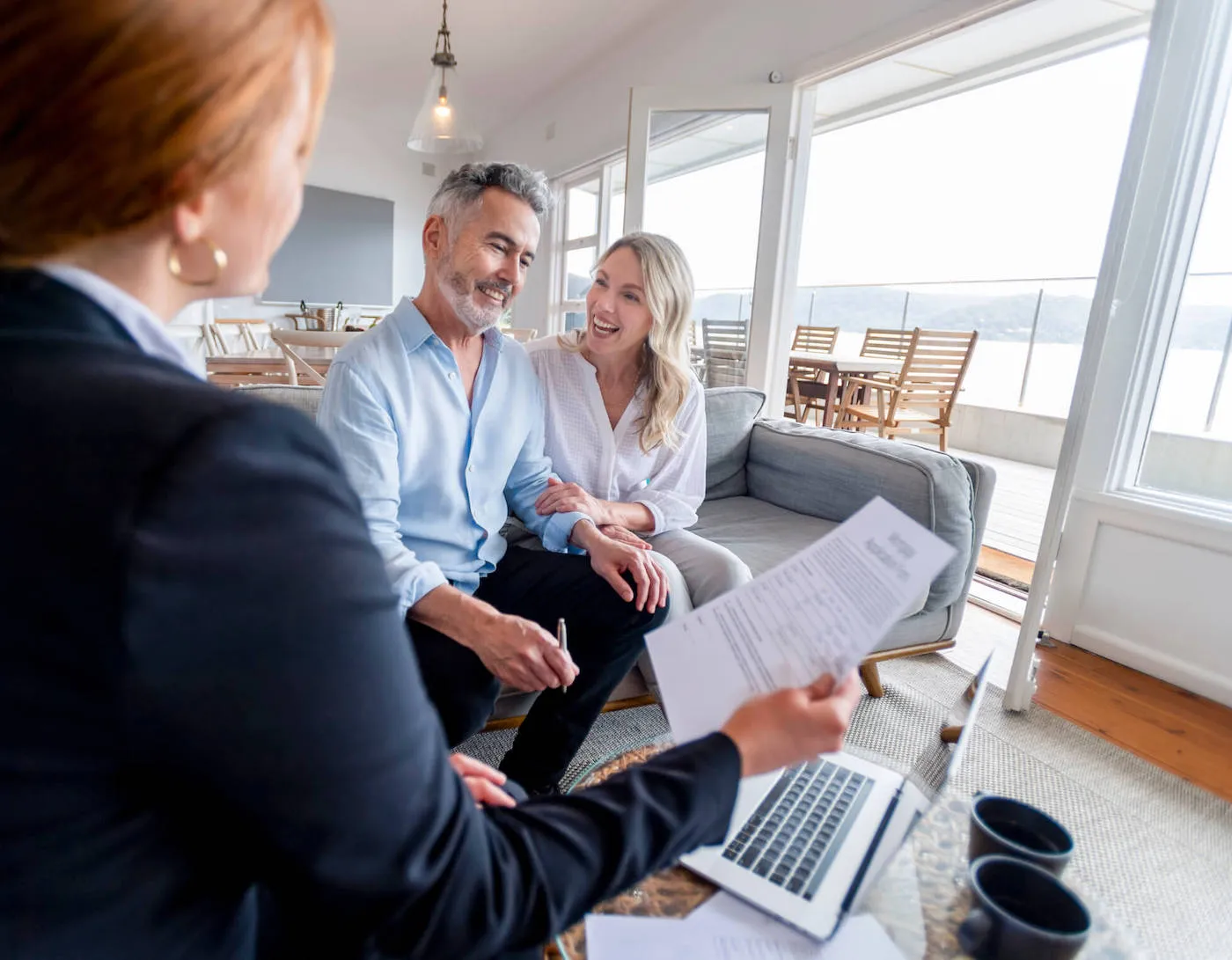 Happy mature couple meeting investments and financial advisor at home.