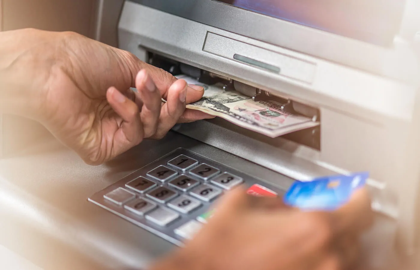 A person at an ATM with a credit card.