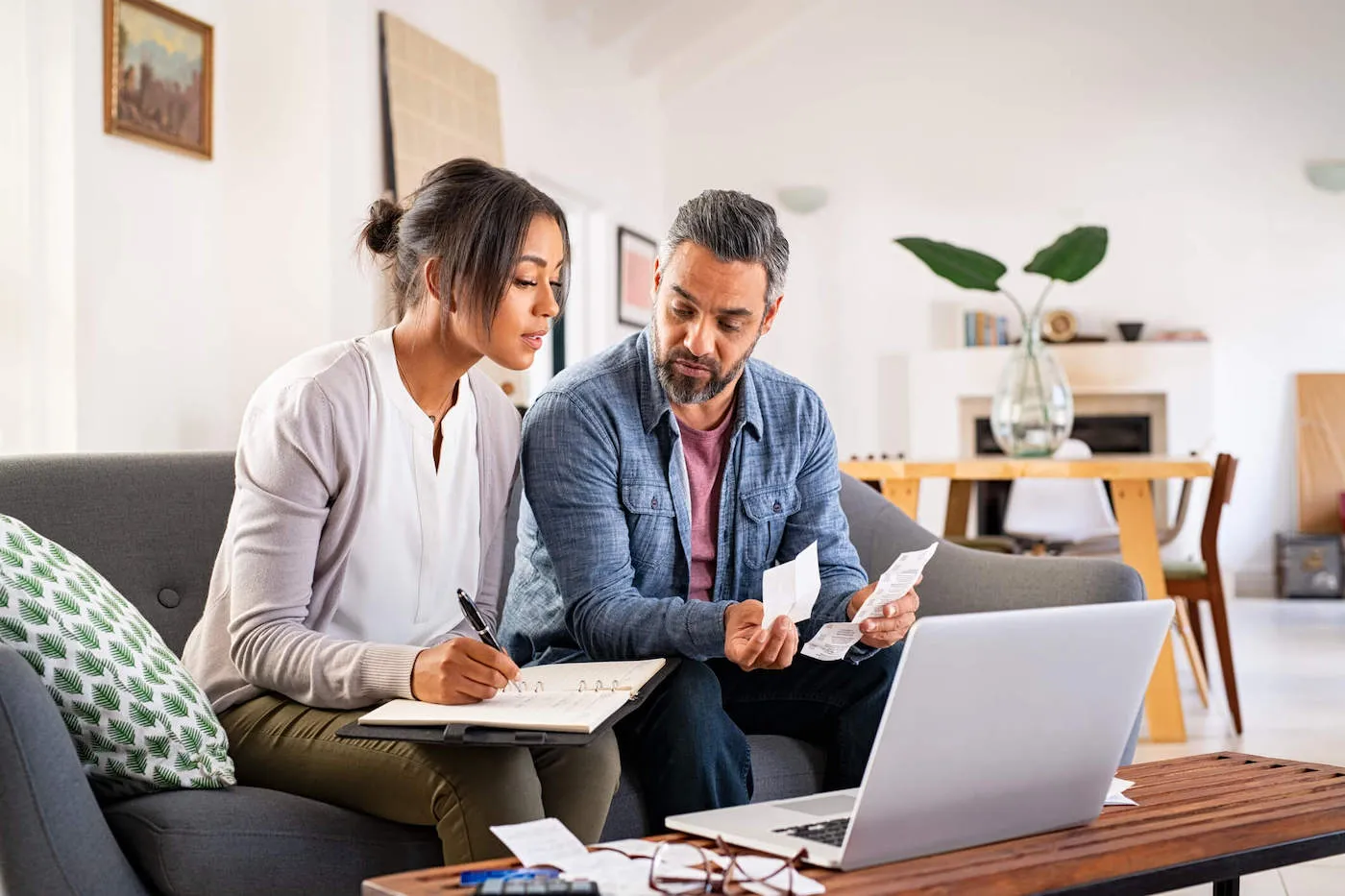 man and woman looking sitting in a living room planning out their investments