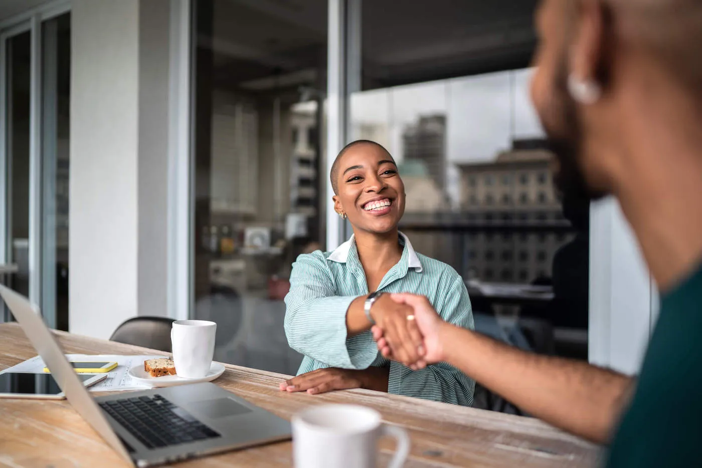 man and woman shaking hands over a table