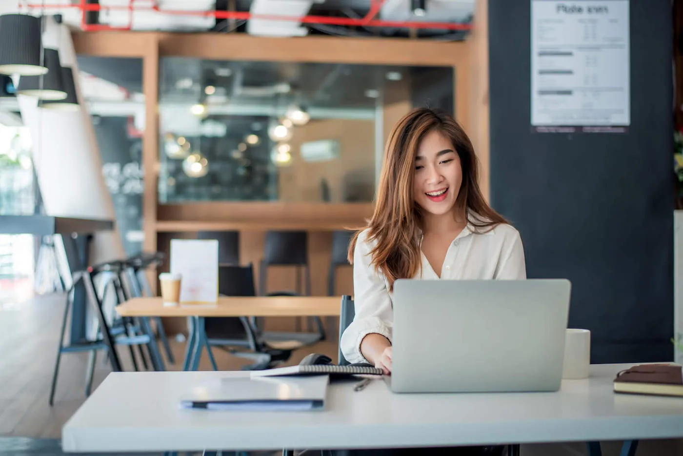 woman seated in front of laptop smiling