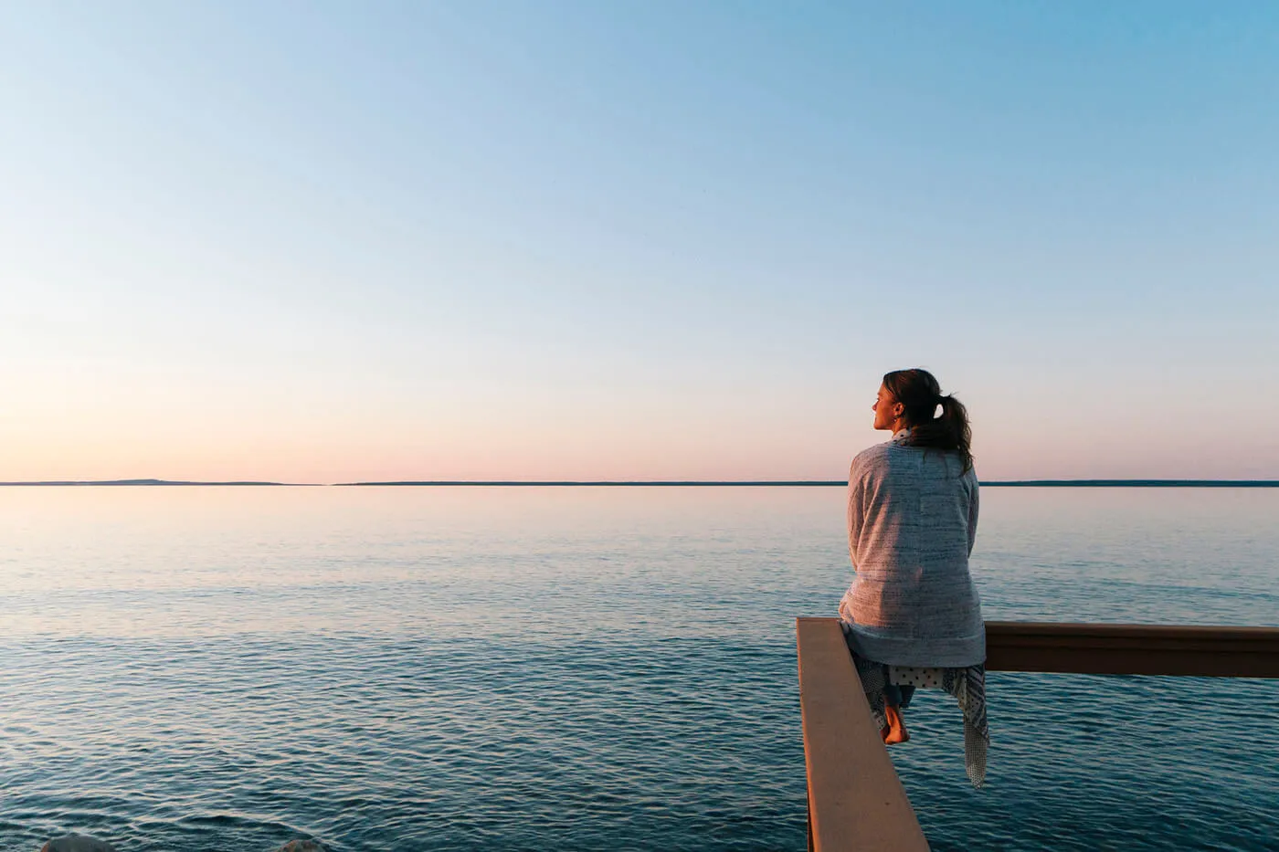 woman sitting overtop water thinking about life insurance