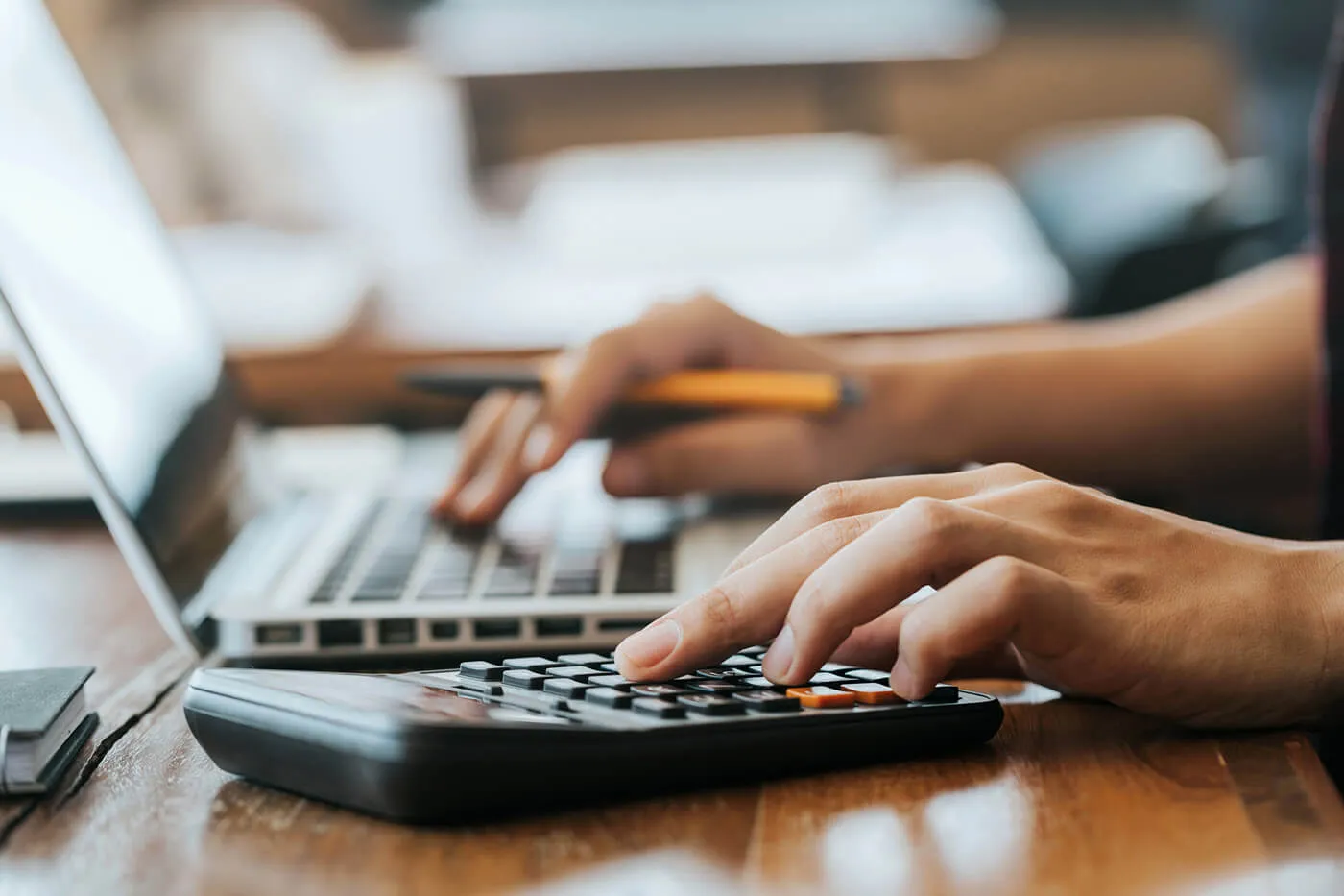 Close up man hands using a calculator and laptop computer for calculating with finance paper, tax, accounting, Accountant concept.