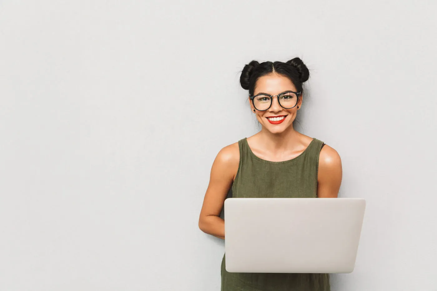 Portrait of a positive young woman isolated, using laptop computer.