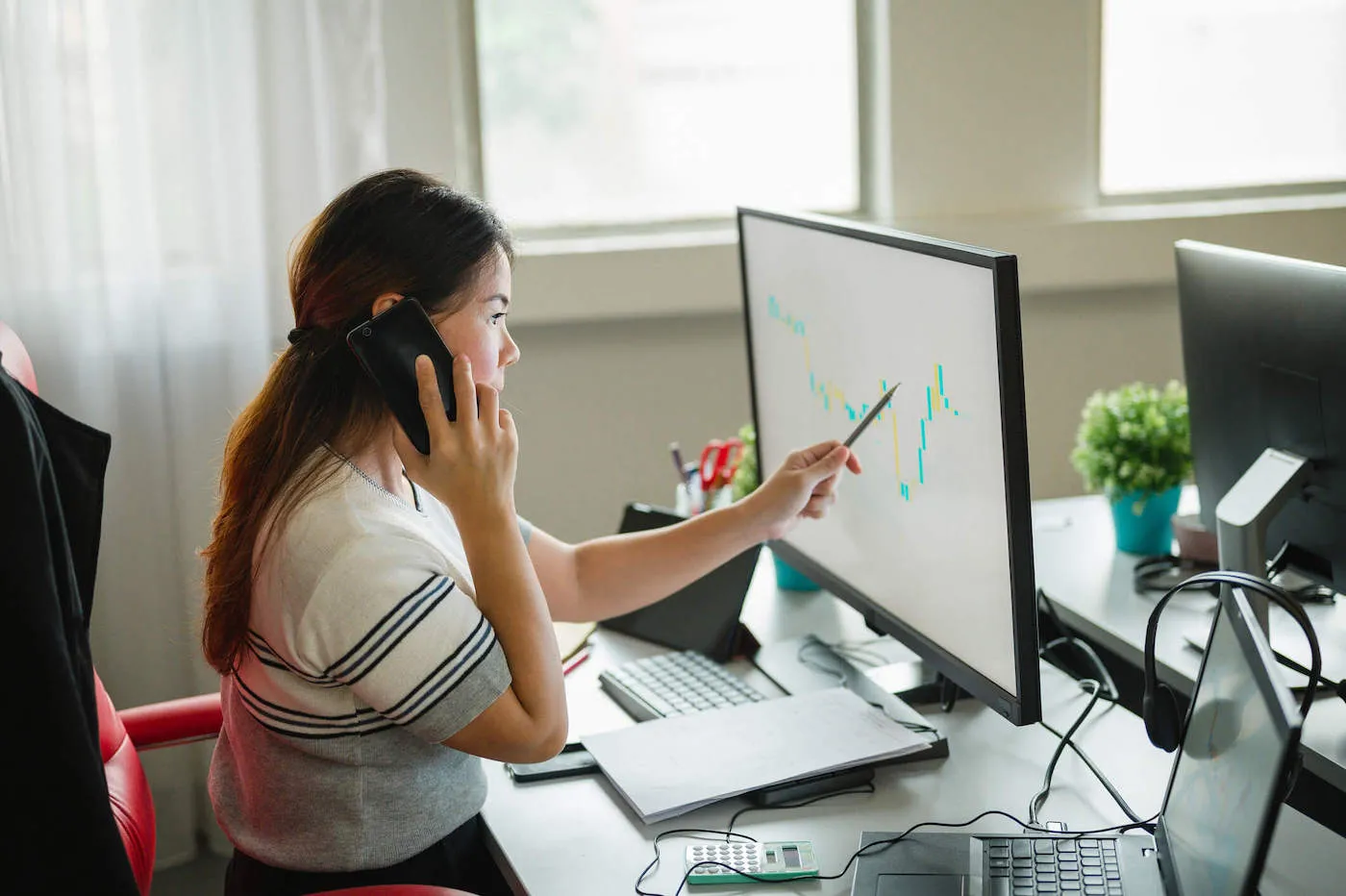 woman seated in front of computer trading options