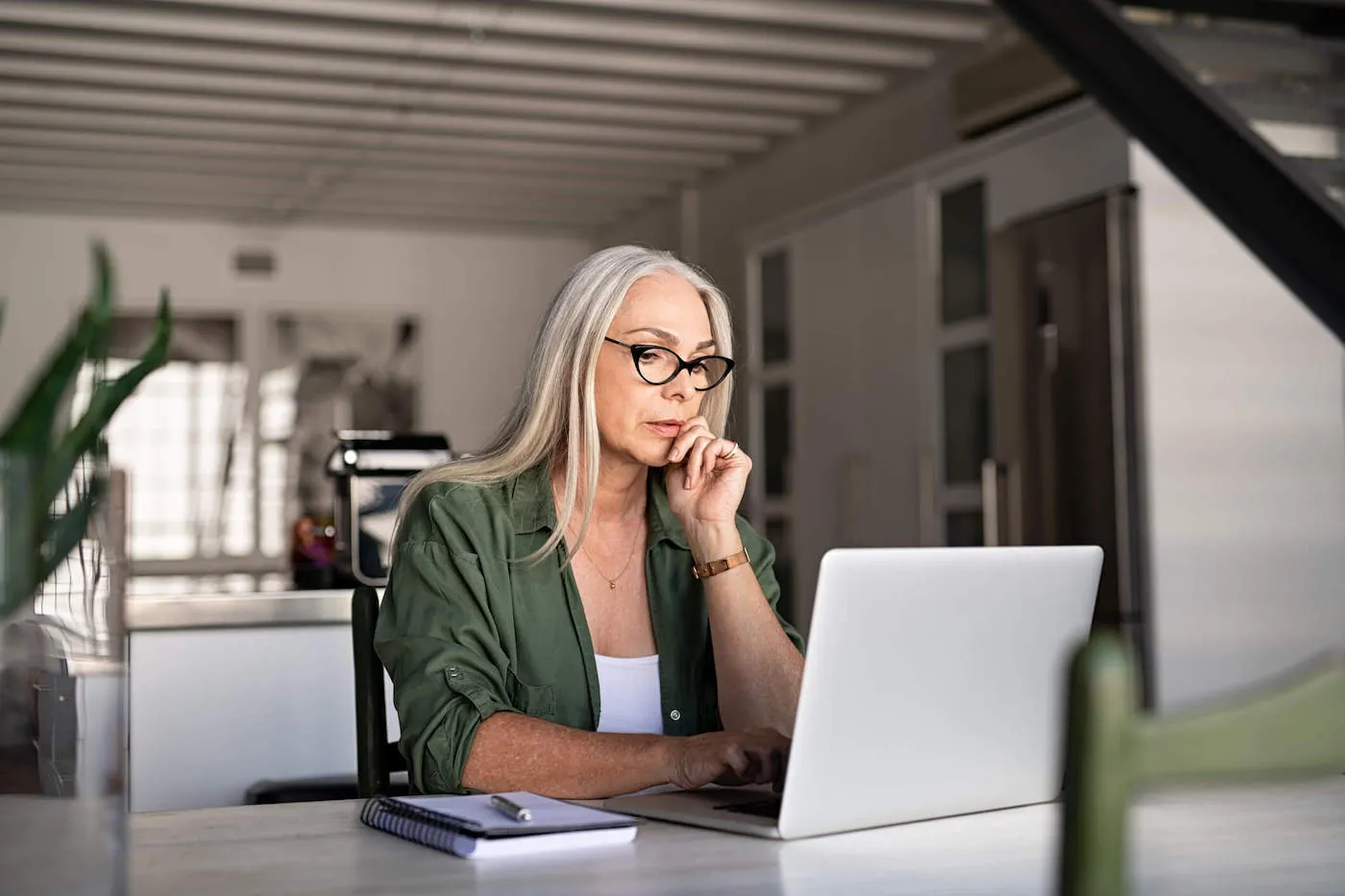 Serious woman analyzing and managing domestic bills and home finance.