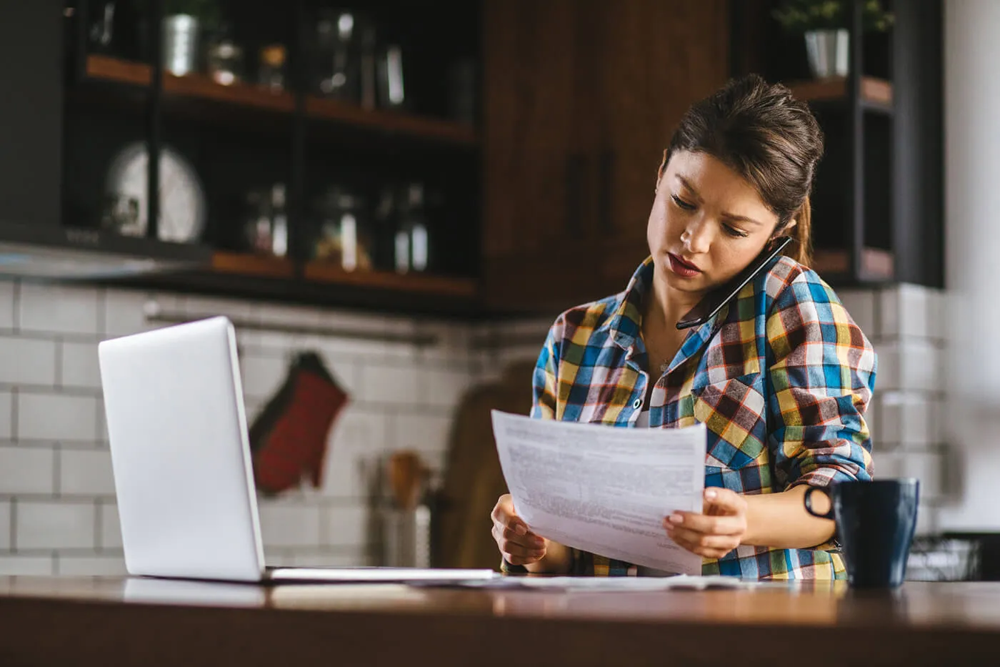 A woman is on the phone while looking at a document.while