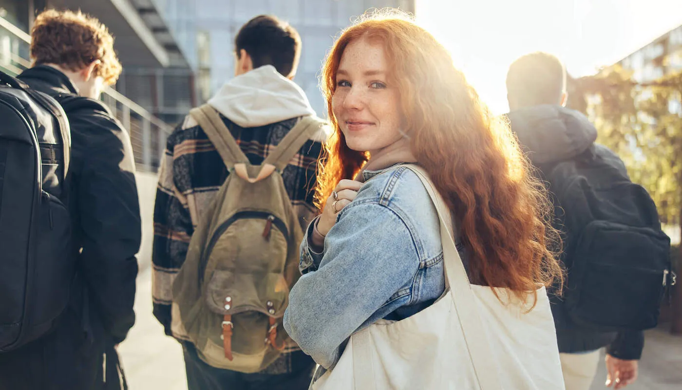 young woman with tote back on college campus