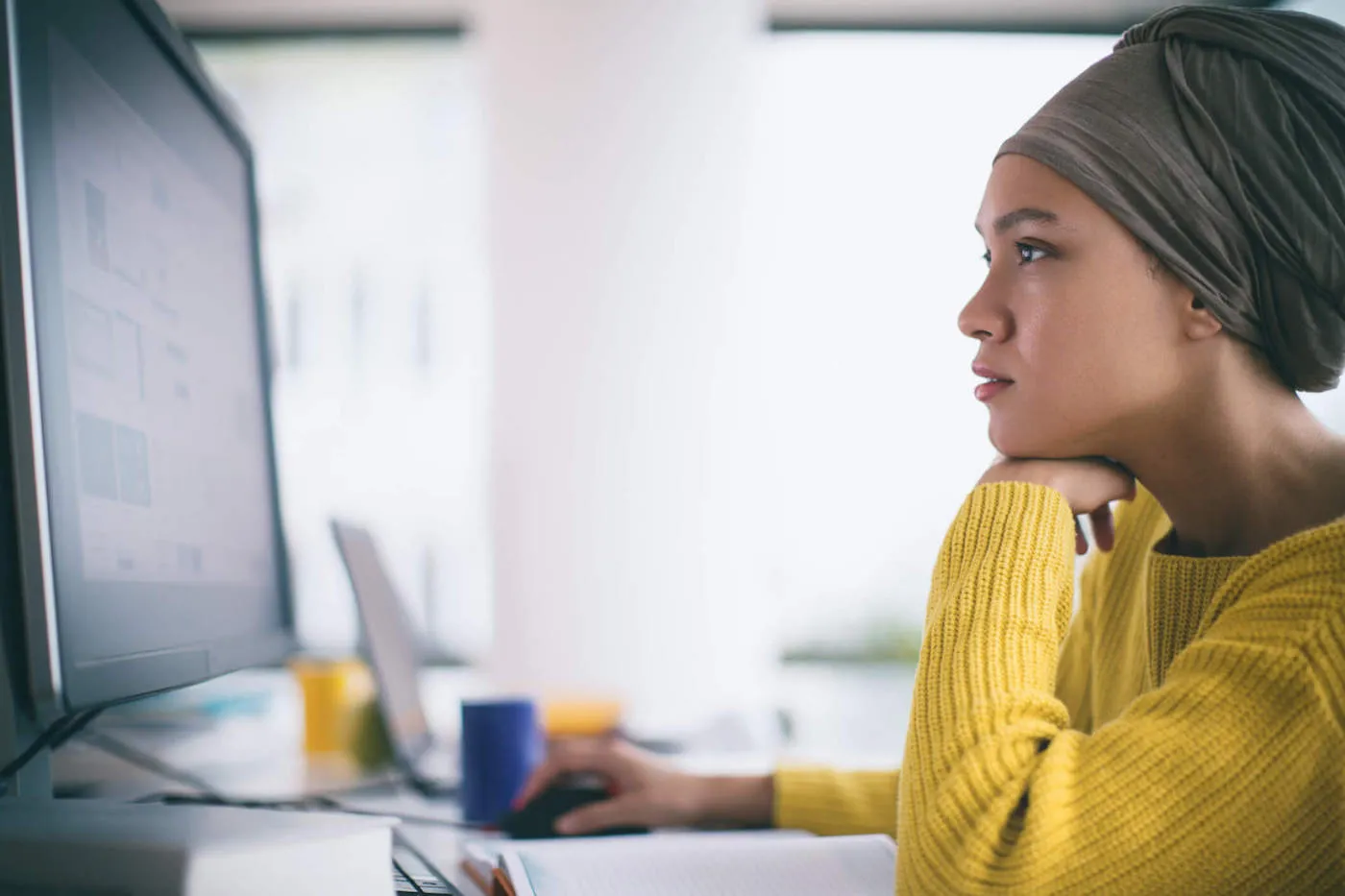 woman in yellow shirt looking people search sites on a computer screen