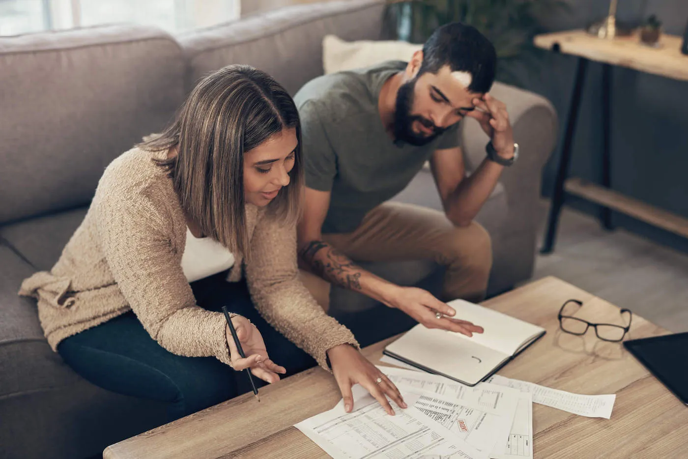 man and woman sitting on a couch looking over papers