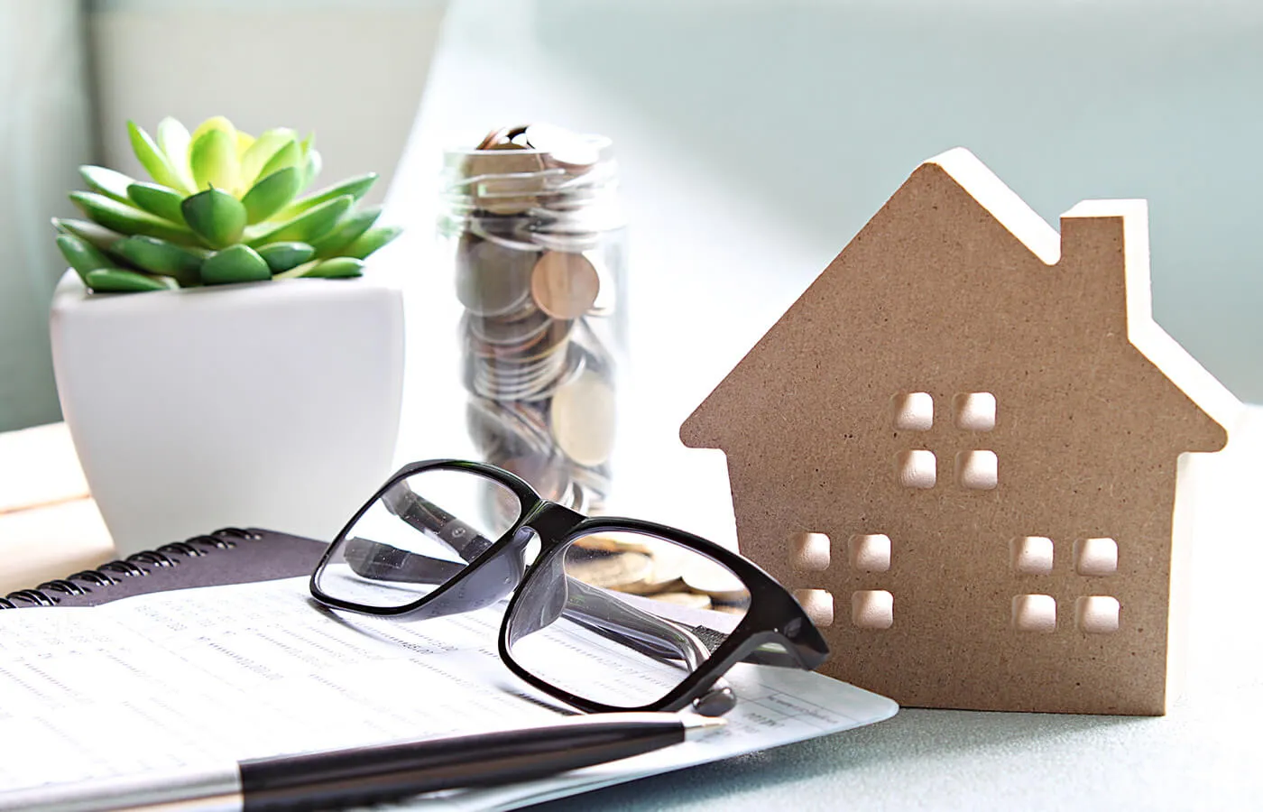 black glasses sitting on notebook next to brown front of house decor