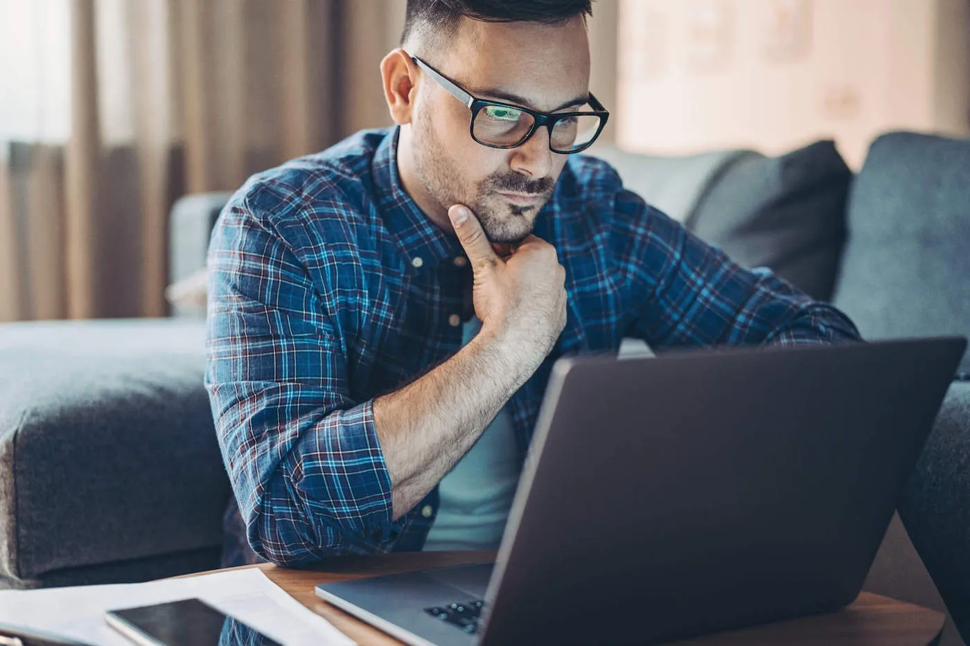 Worried man in front of a laptop at home.