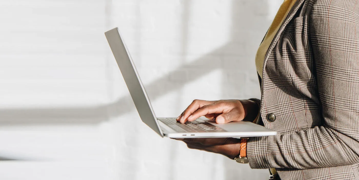 African American adult businesswoman holding laptop.