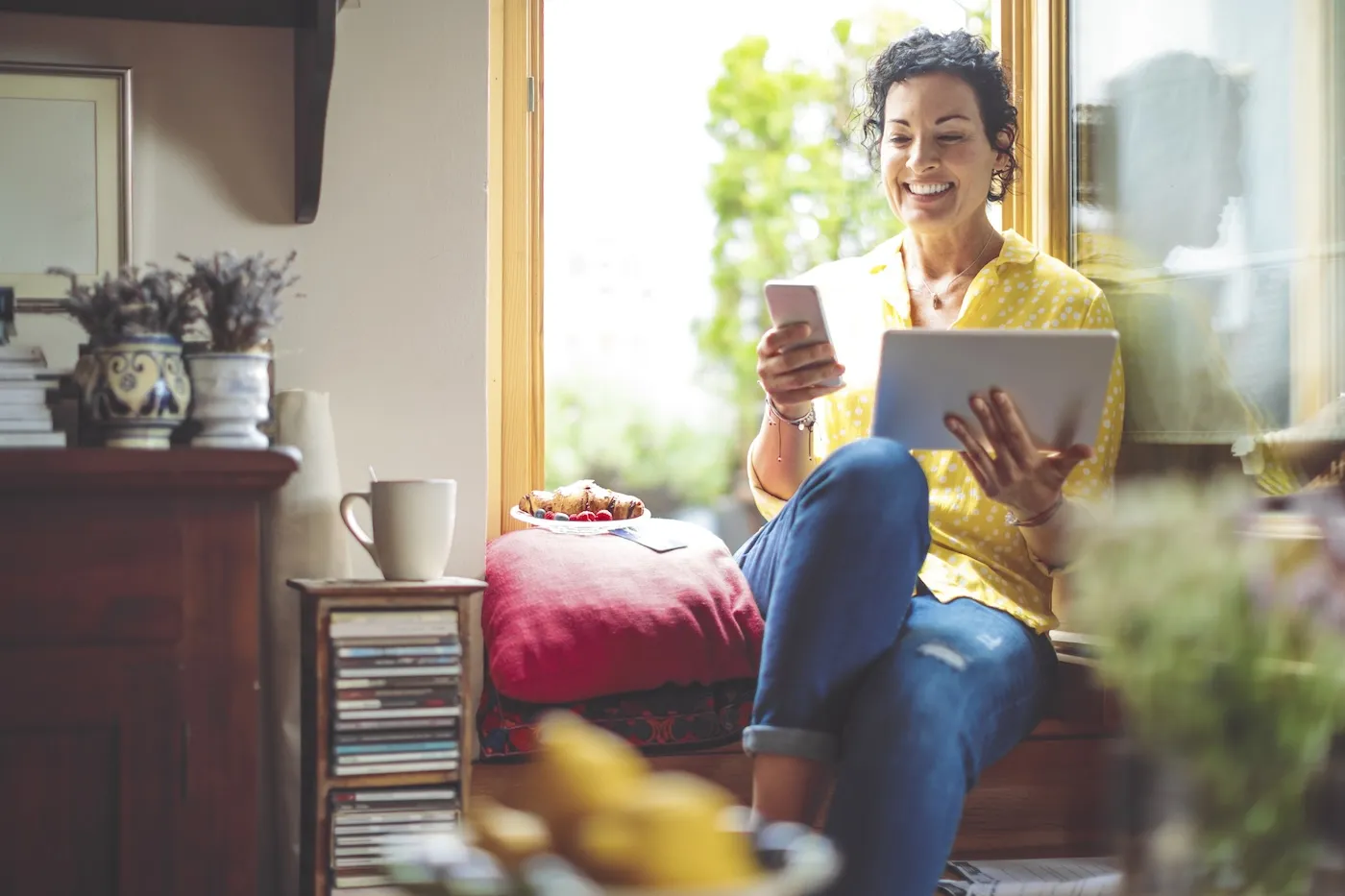 Mature woman is purchasing online at home with her credit card.