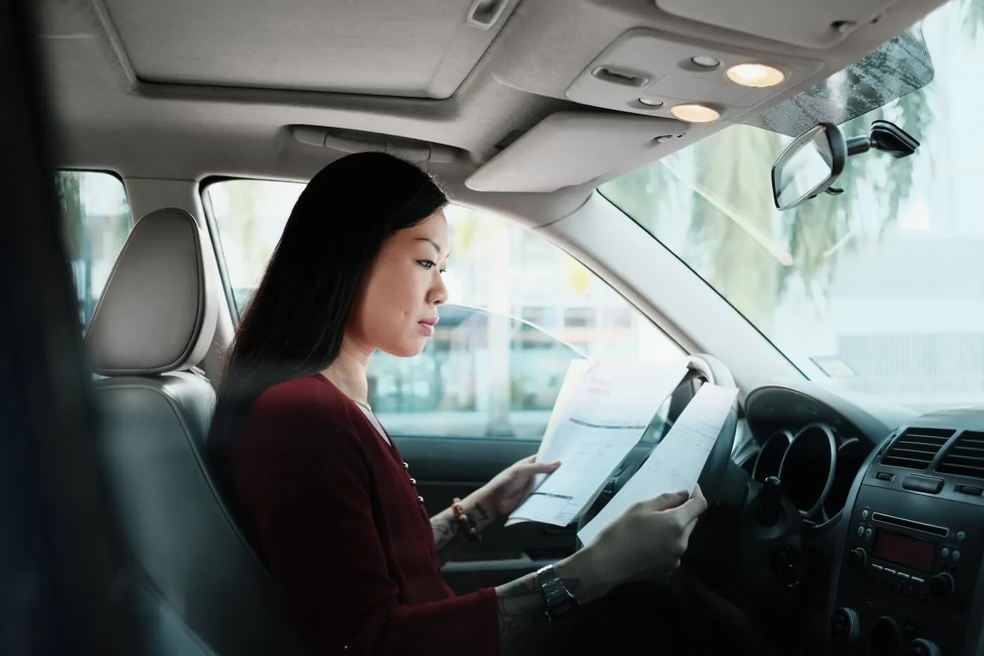 Woman reading a letter in her car