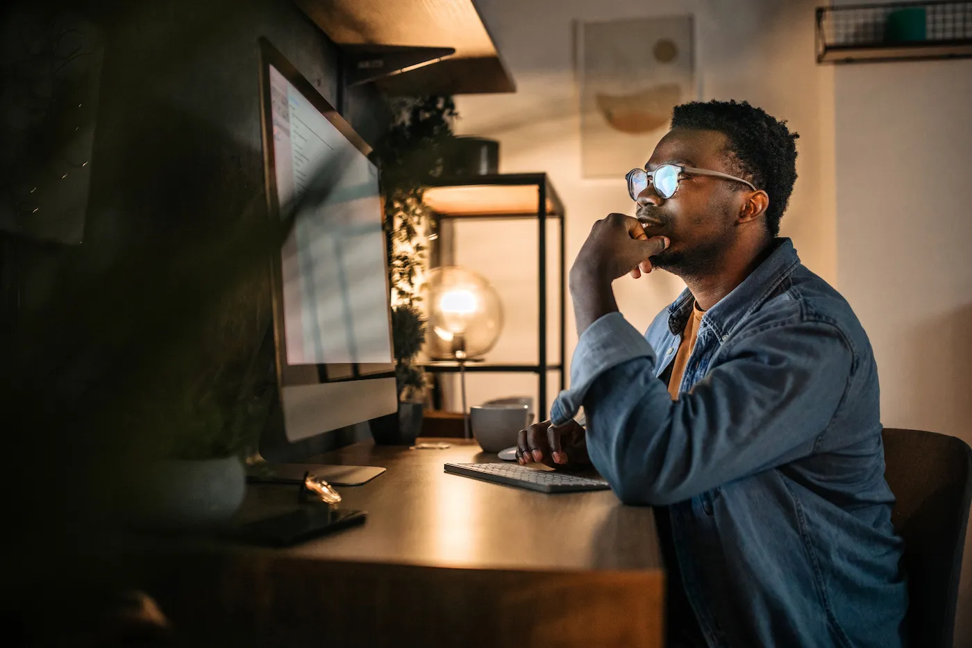 Young man using desktop computer to decide between autopay or online bill pay.