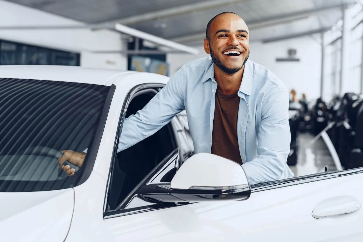 Happy man getting out of his new car