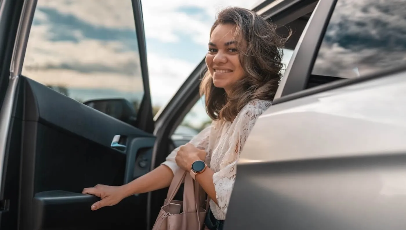 Smiling woman getting out of the car