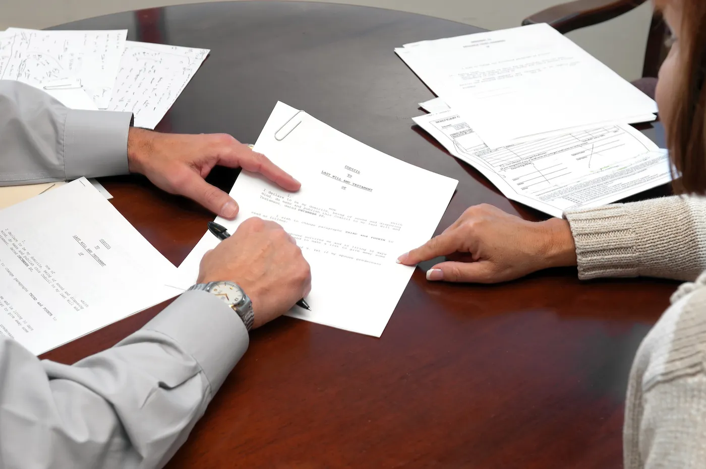 Two people reviewing a will to name a beneficiary.