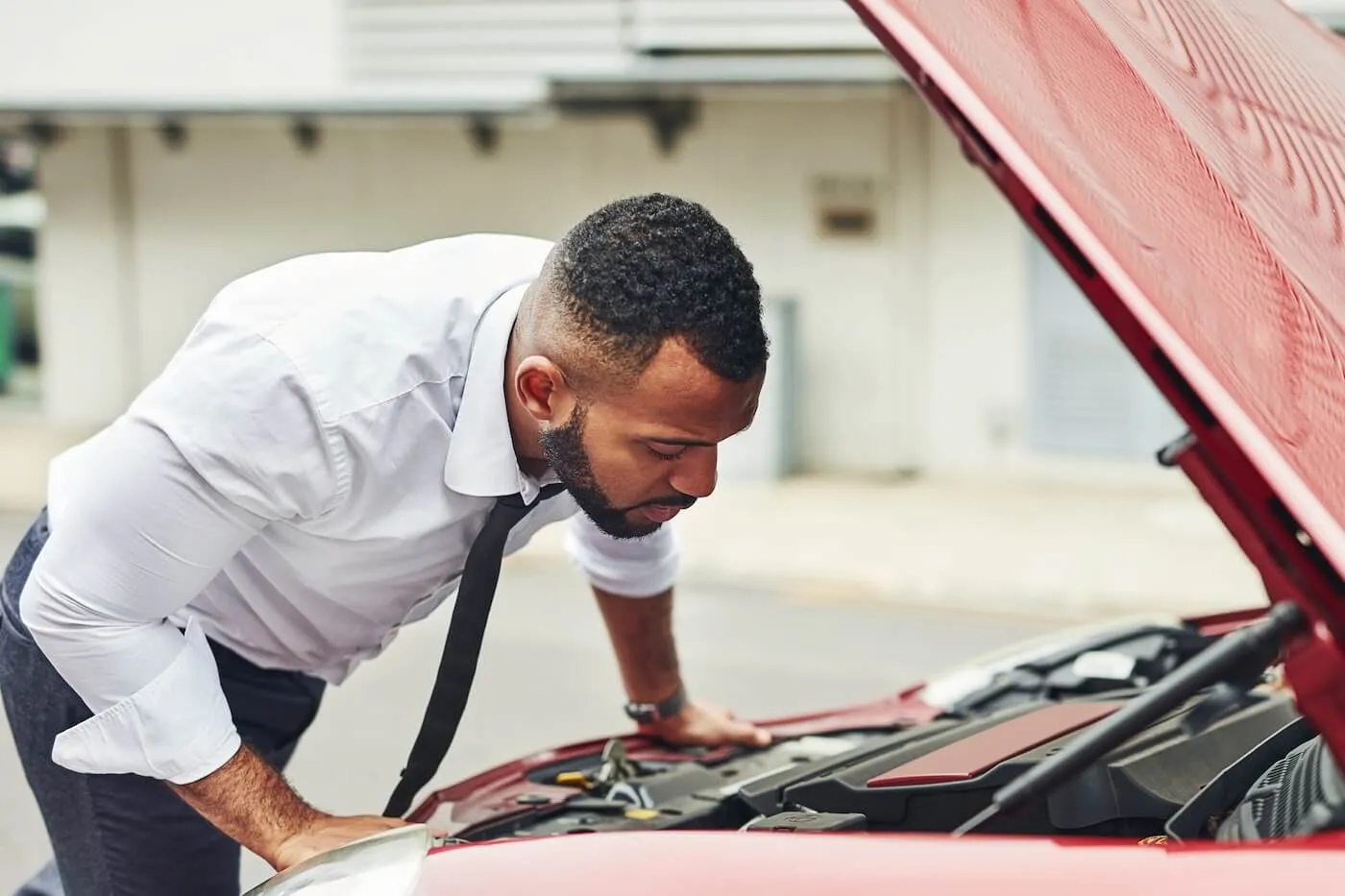 Concerned businessman looking under the car hood