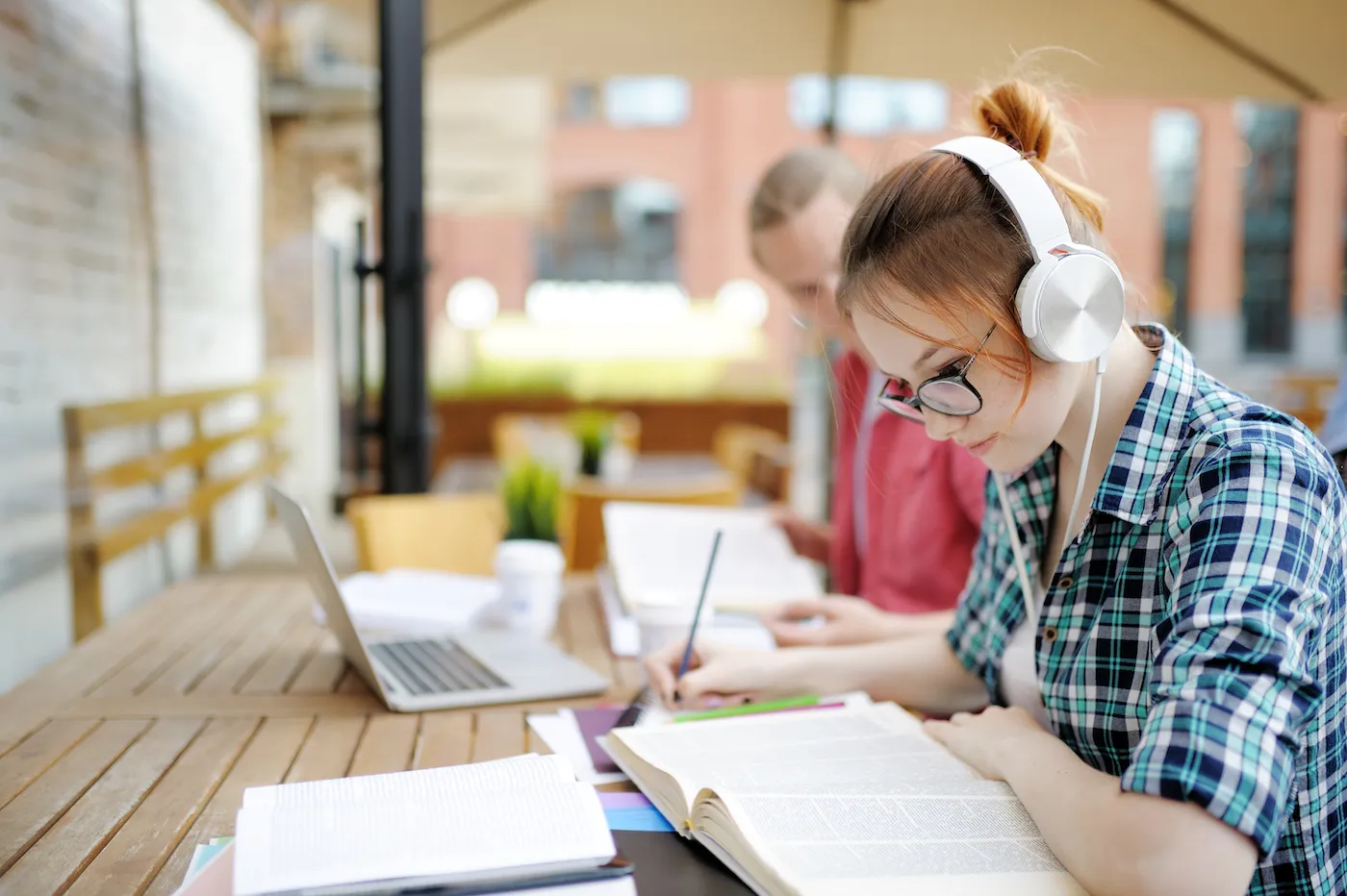 Young couple of students with books and notes outdoors.