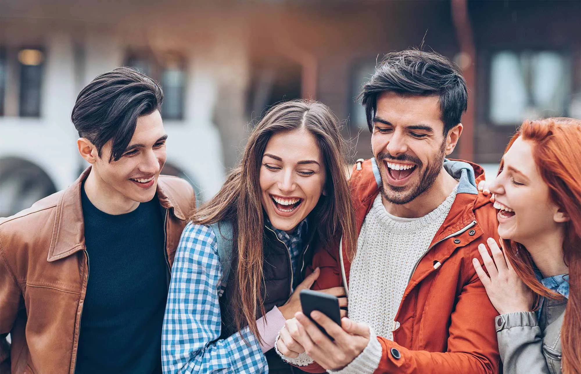 college student group of two boys and two girls laughing while walking around.