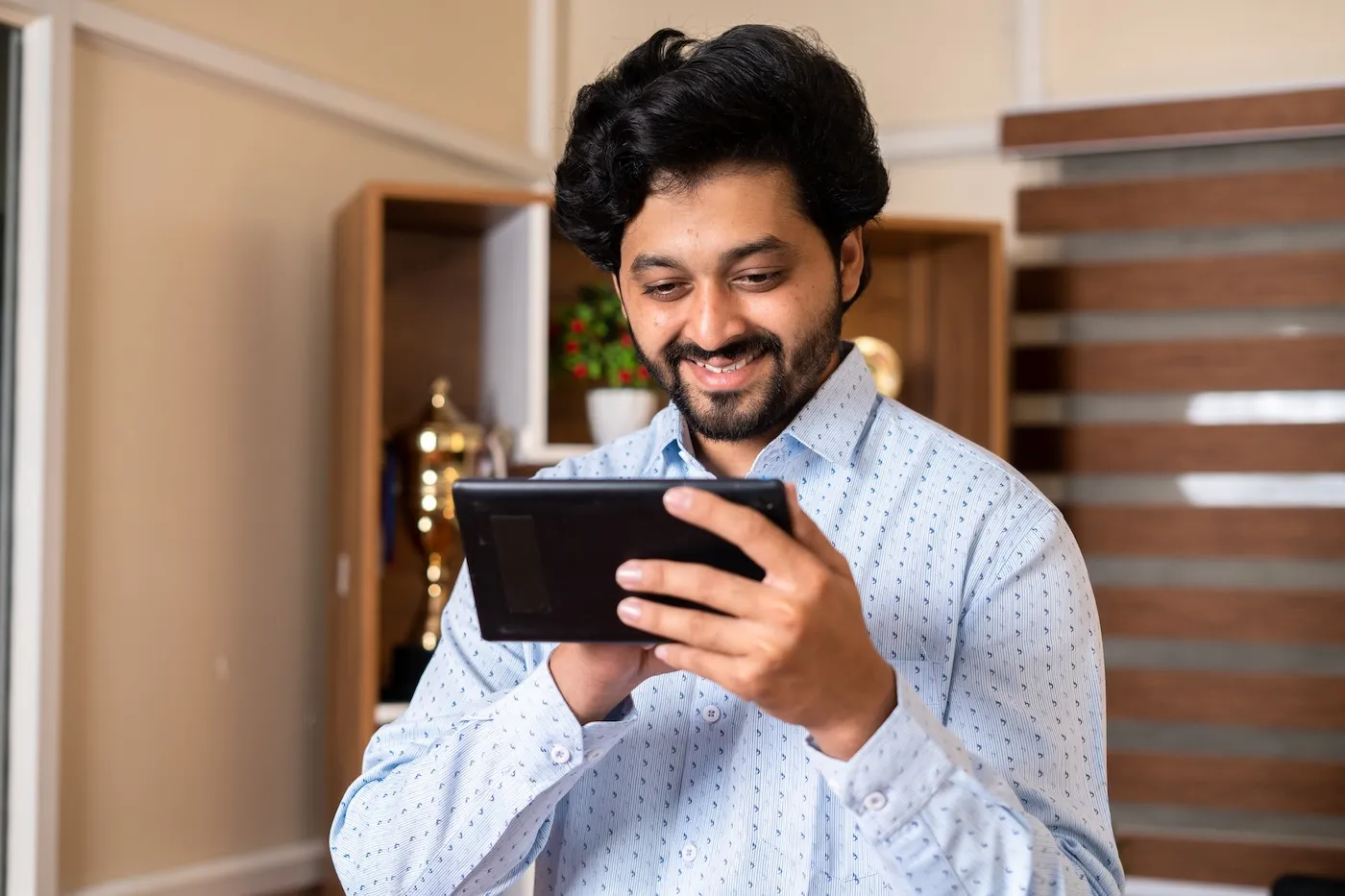 Happy smiling man using his smartphone to check conforming loan limits.