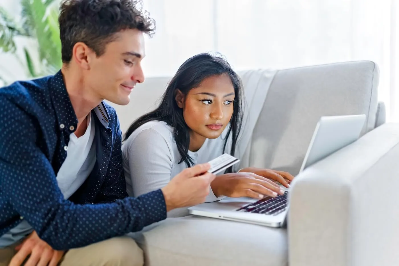 Couple using credit card for online shopping at home