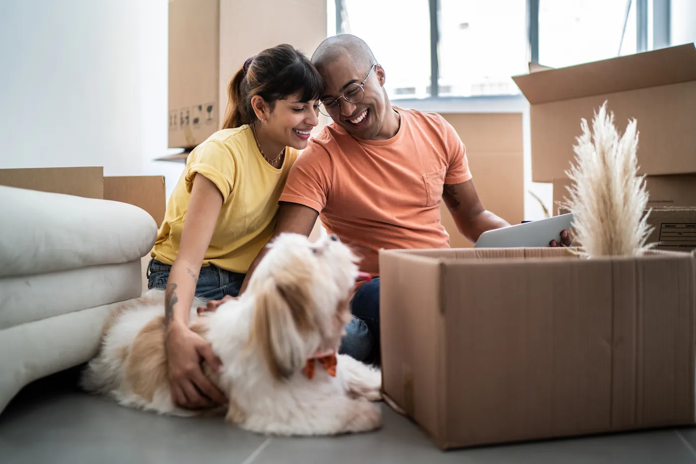 Young couple working on a plan for buying a house, sitting with their dog