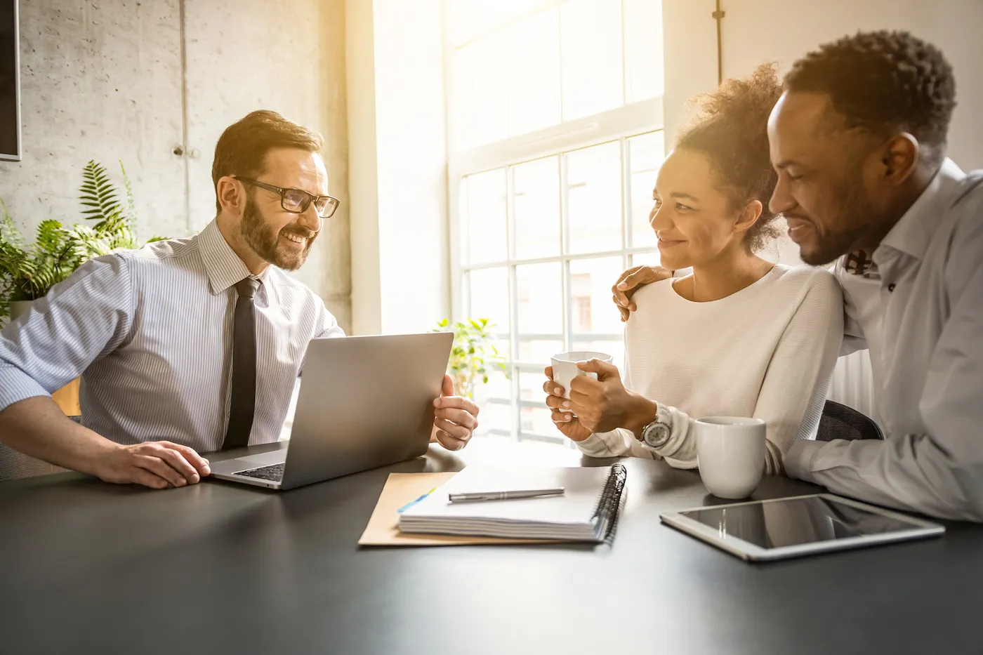 Couple sitting at a table consults with an agent about a mortgage buydown.