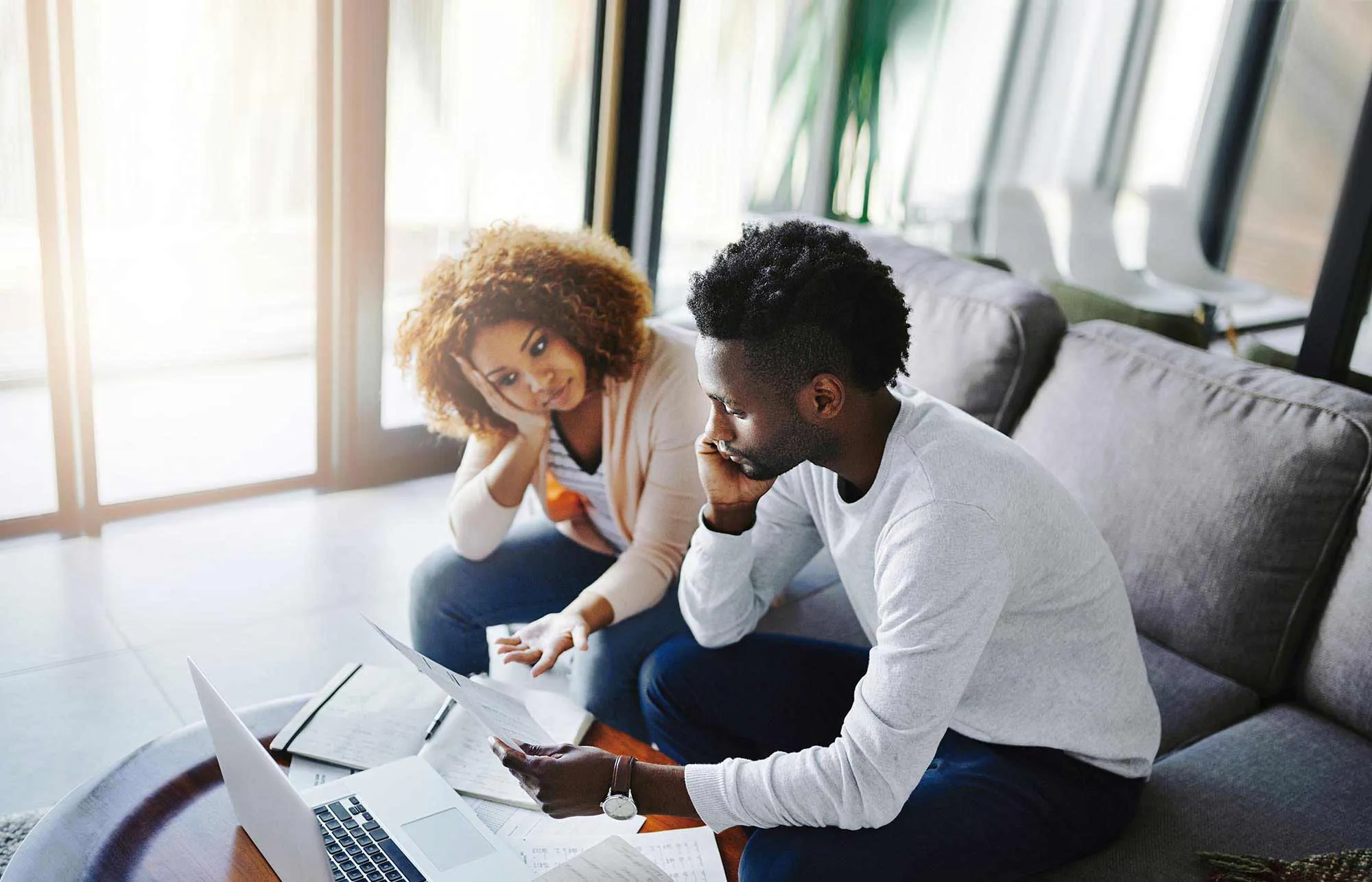 A couple reviewing financial documents in their living room.