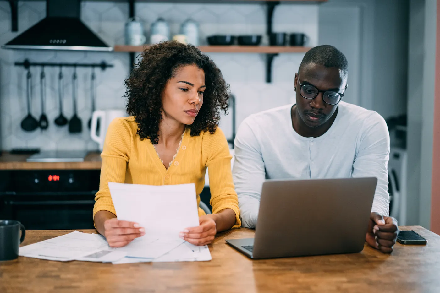 Shot of young couple using a laptop to research high yield savings account rates.