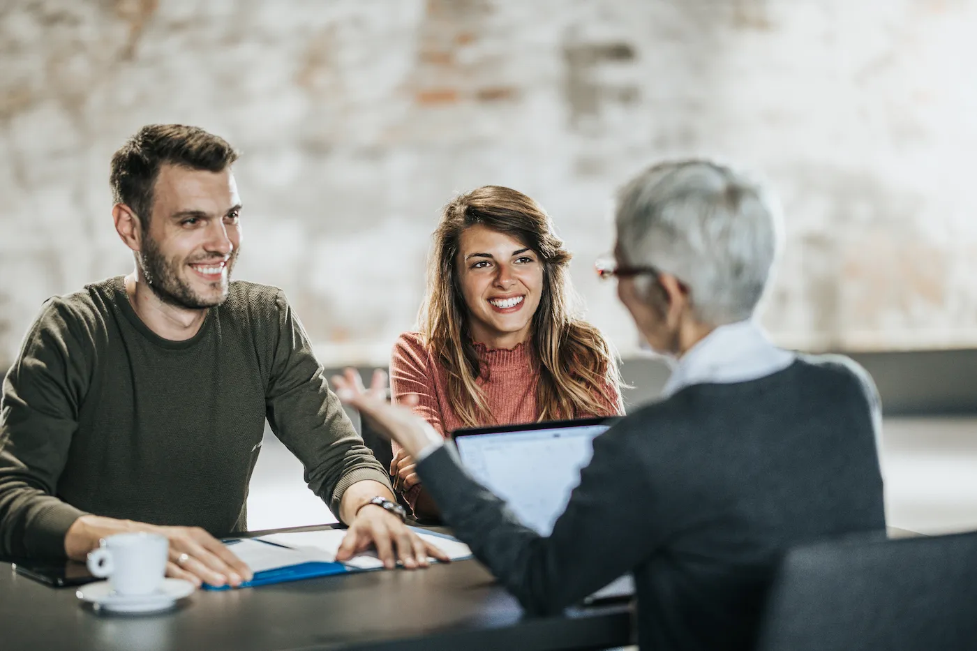 Happy couple communicating with their bank manager during a meeting in the office.