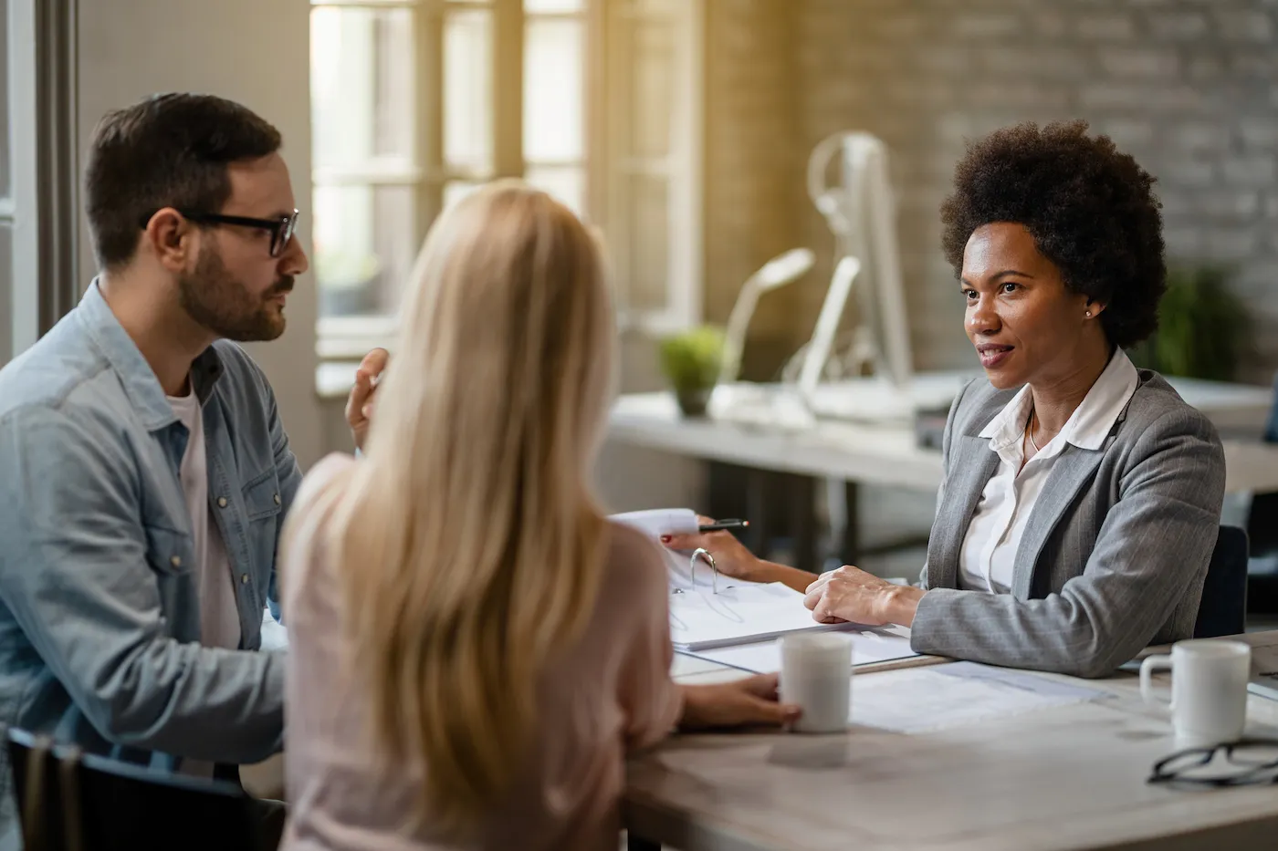 Couple meeting with peer-to-peer loan advisor in an office.