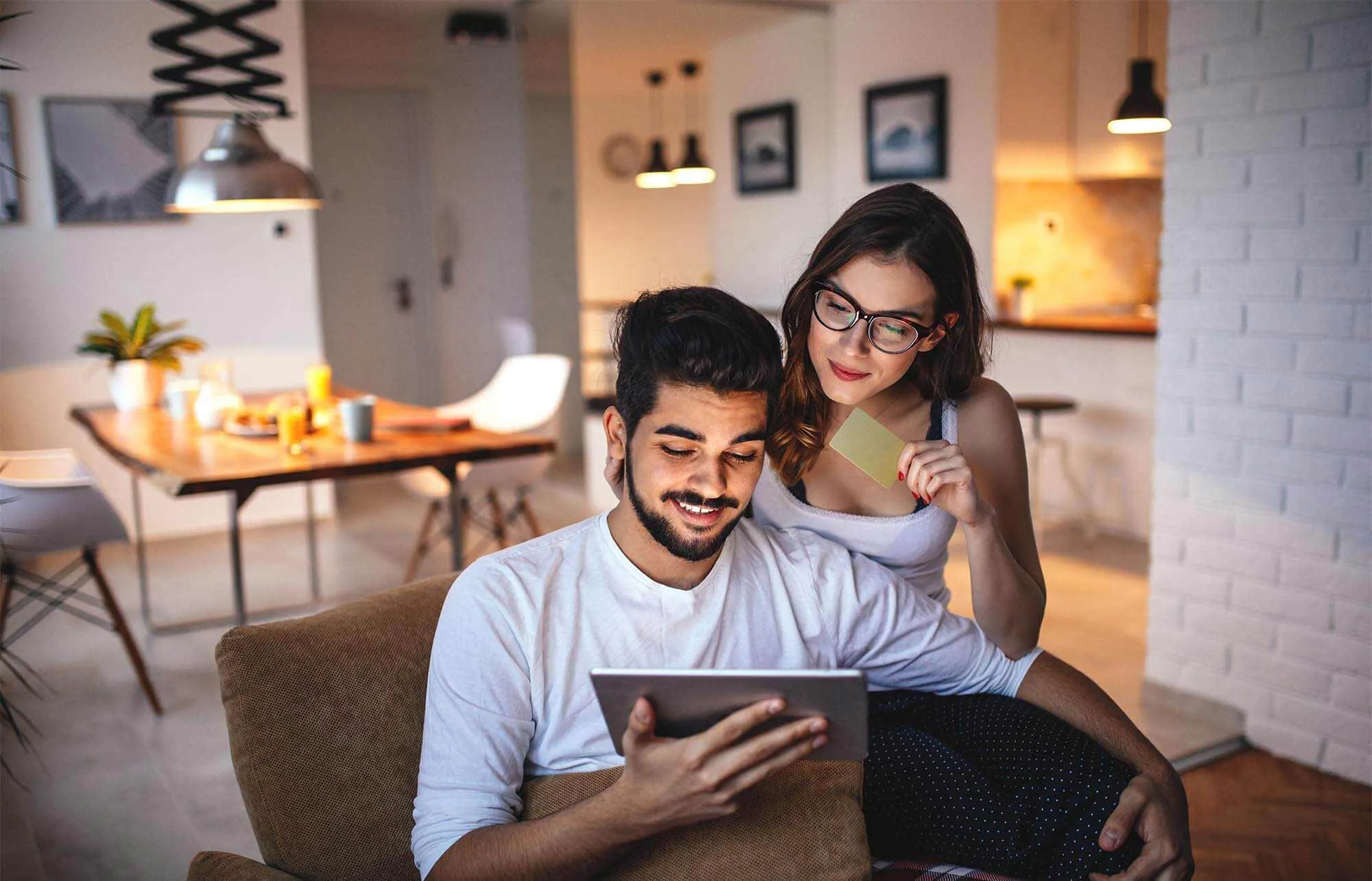 Young couple researching how to diversify investments on a tablet