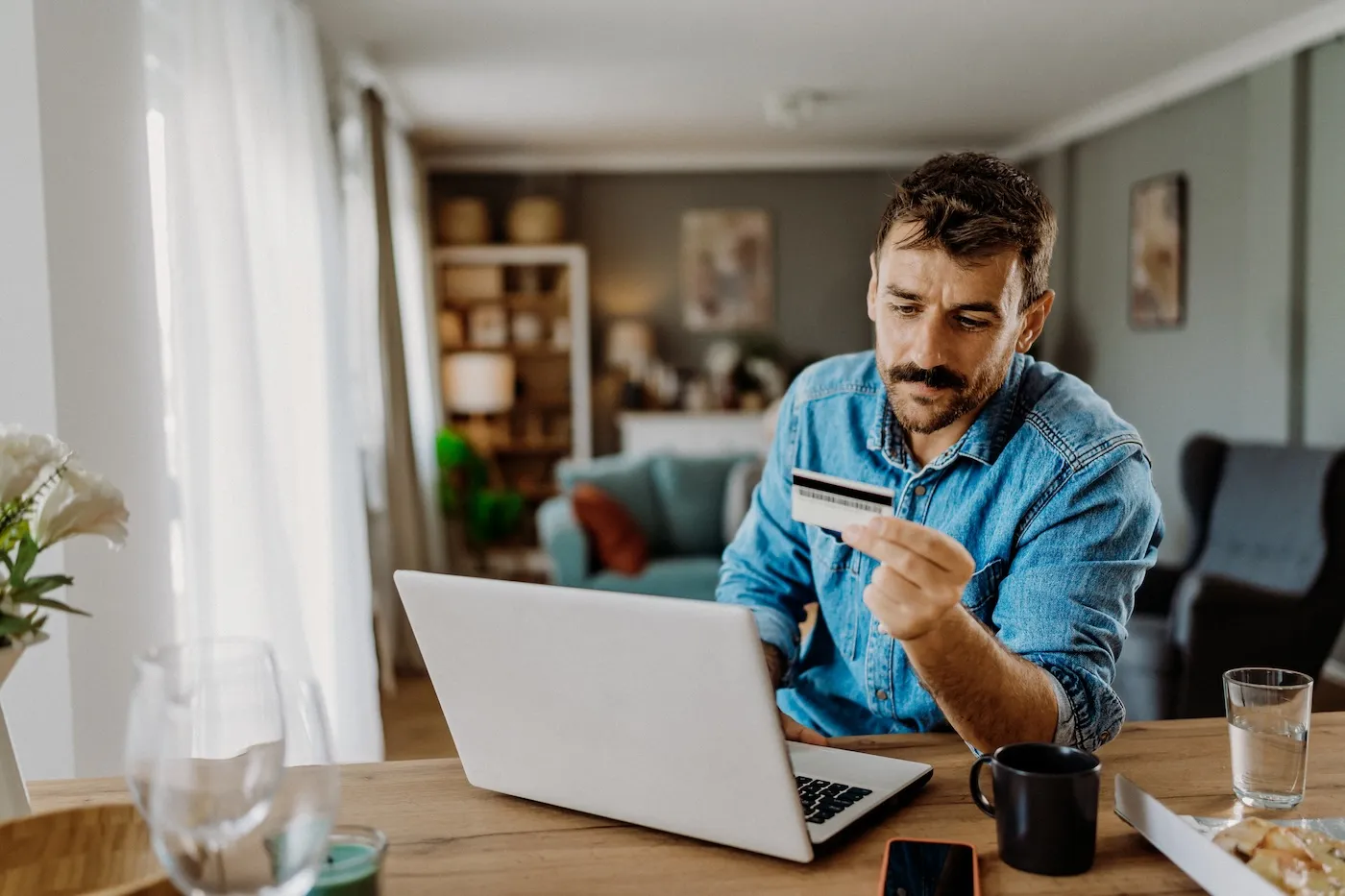 Young man using his credit card on the laptop