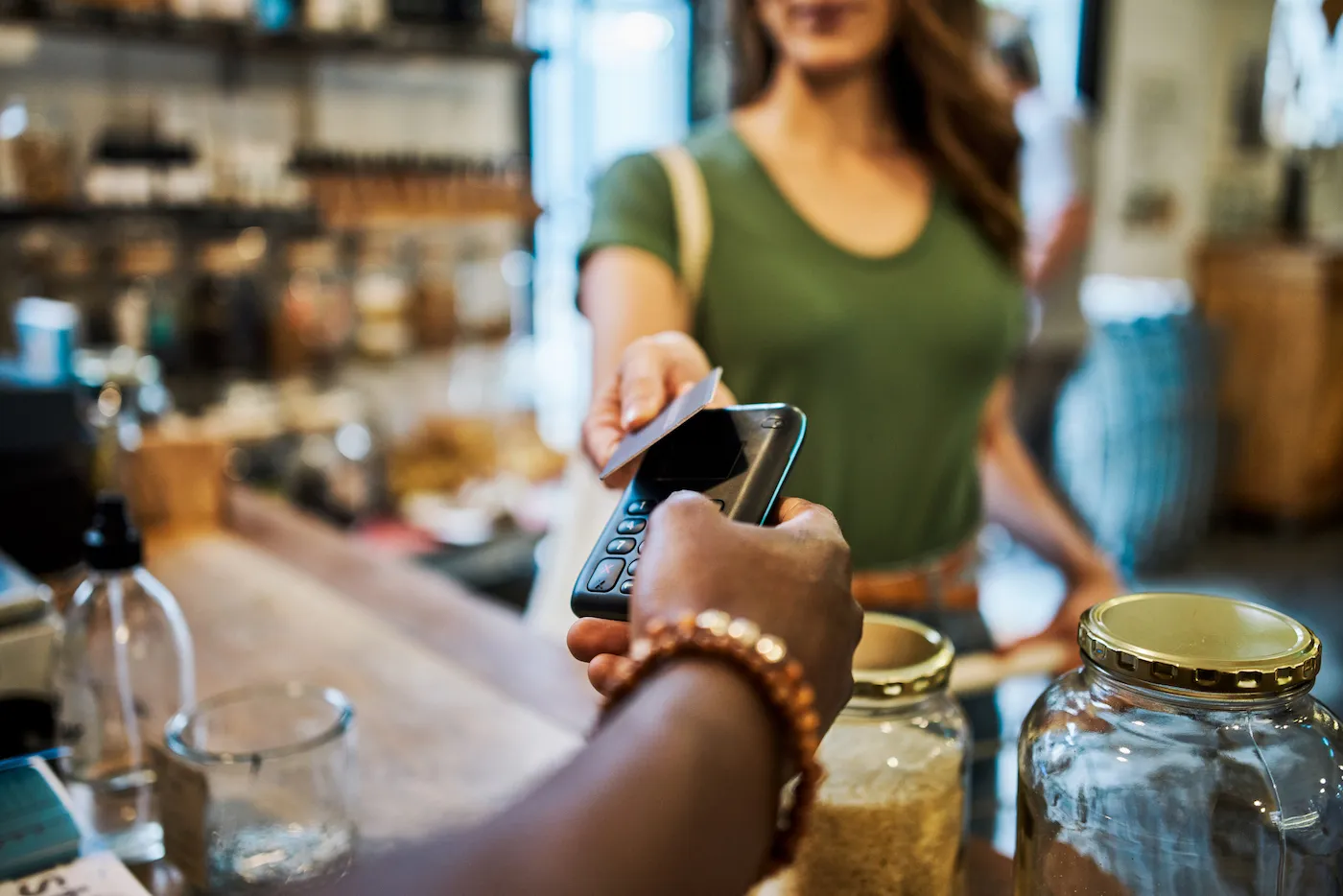 Shot of a cashier helping a customer pay with a credit card in a grocery store