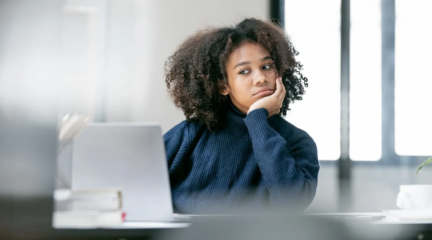 A concerned woman with a laptop checking her credit report.