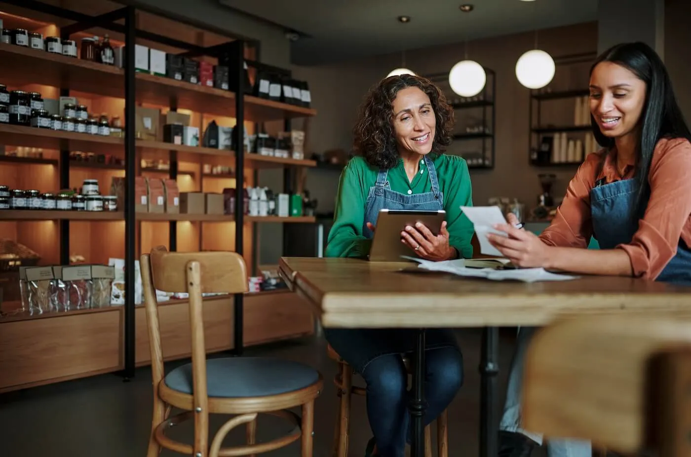 Two women reviewing business finance in their small shop