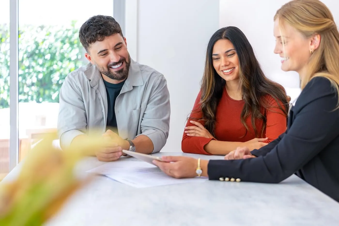 A couple discussing auto loan terms with a female agent